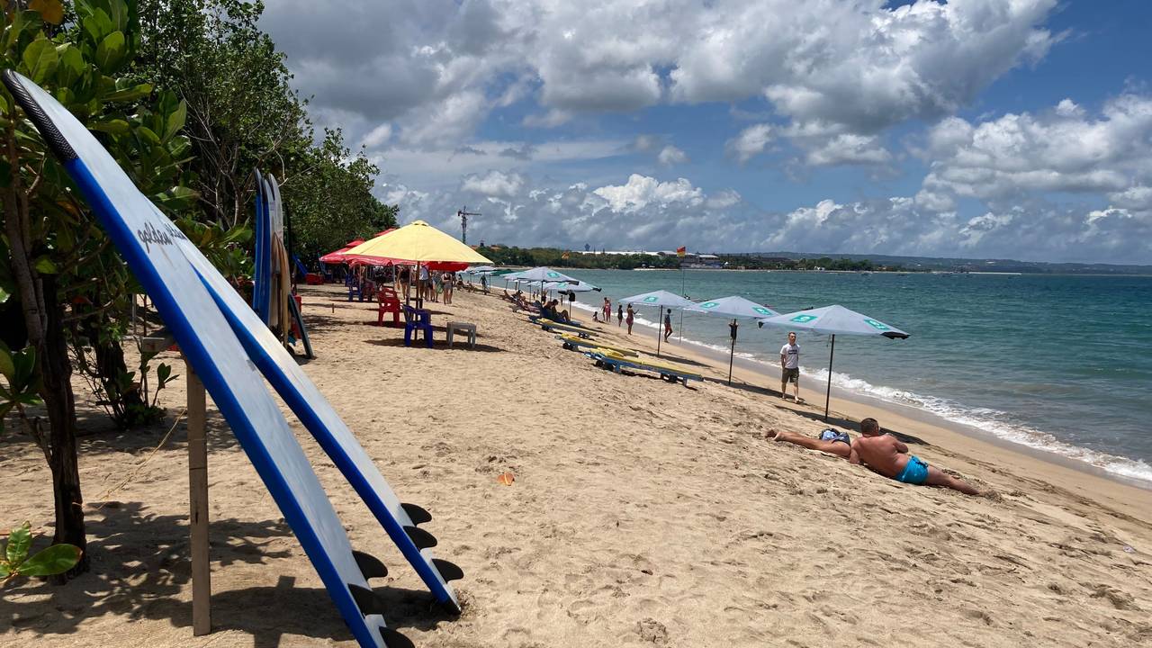 Surfbretter und Sonnenschirme stehen am Strand auf Bali.