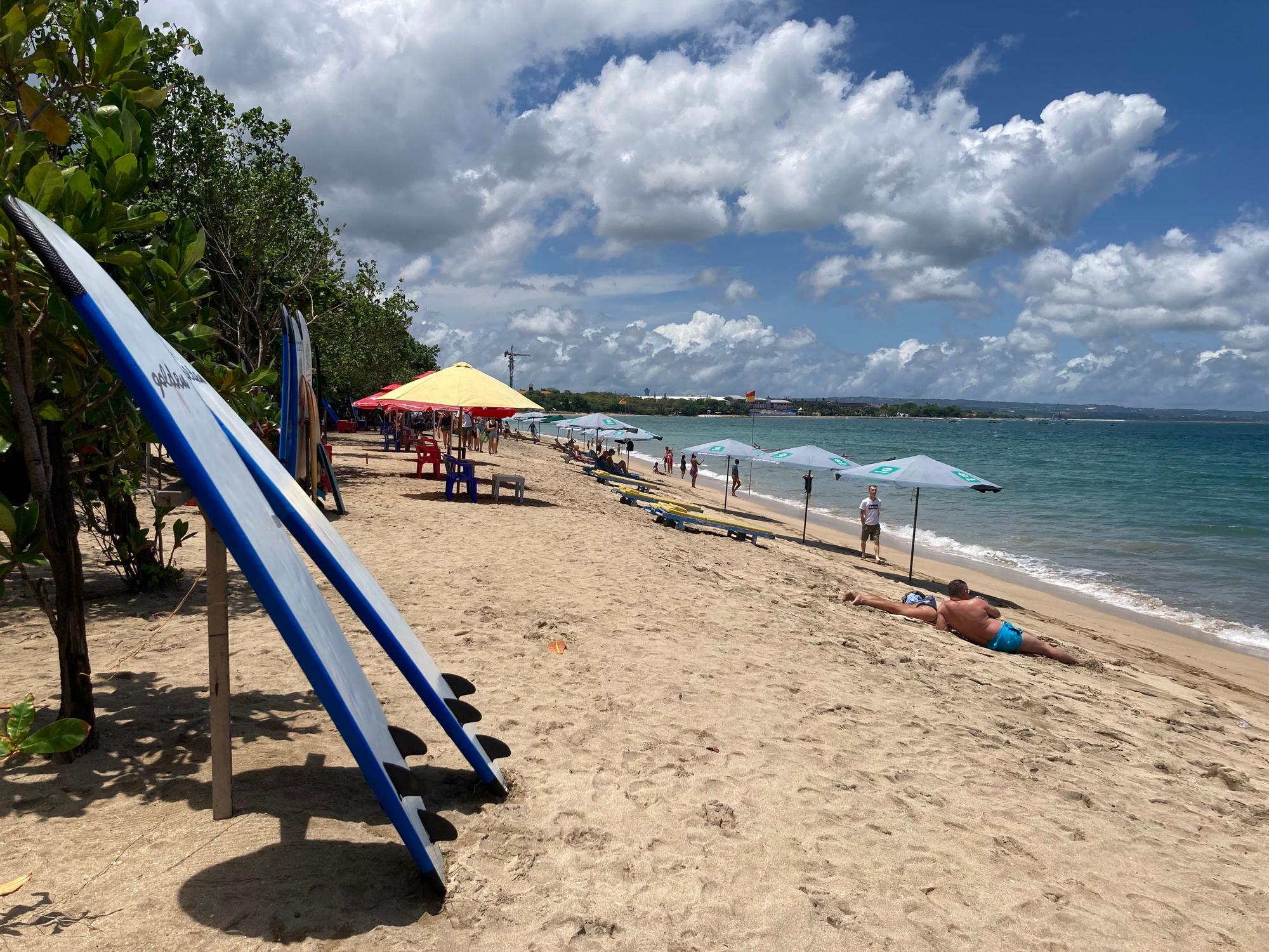 Surfbretter und Sonnenschirme stehen am Strand auf Bali.
