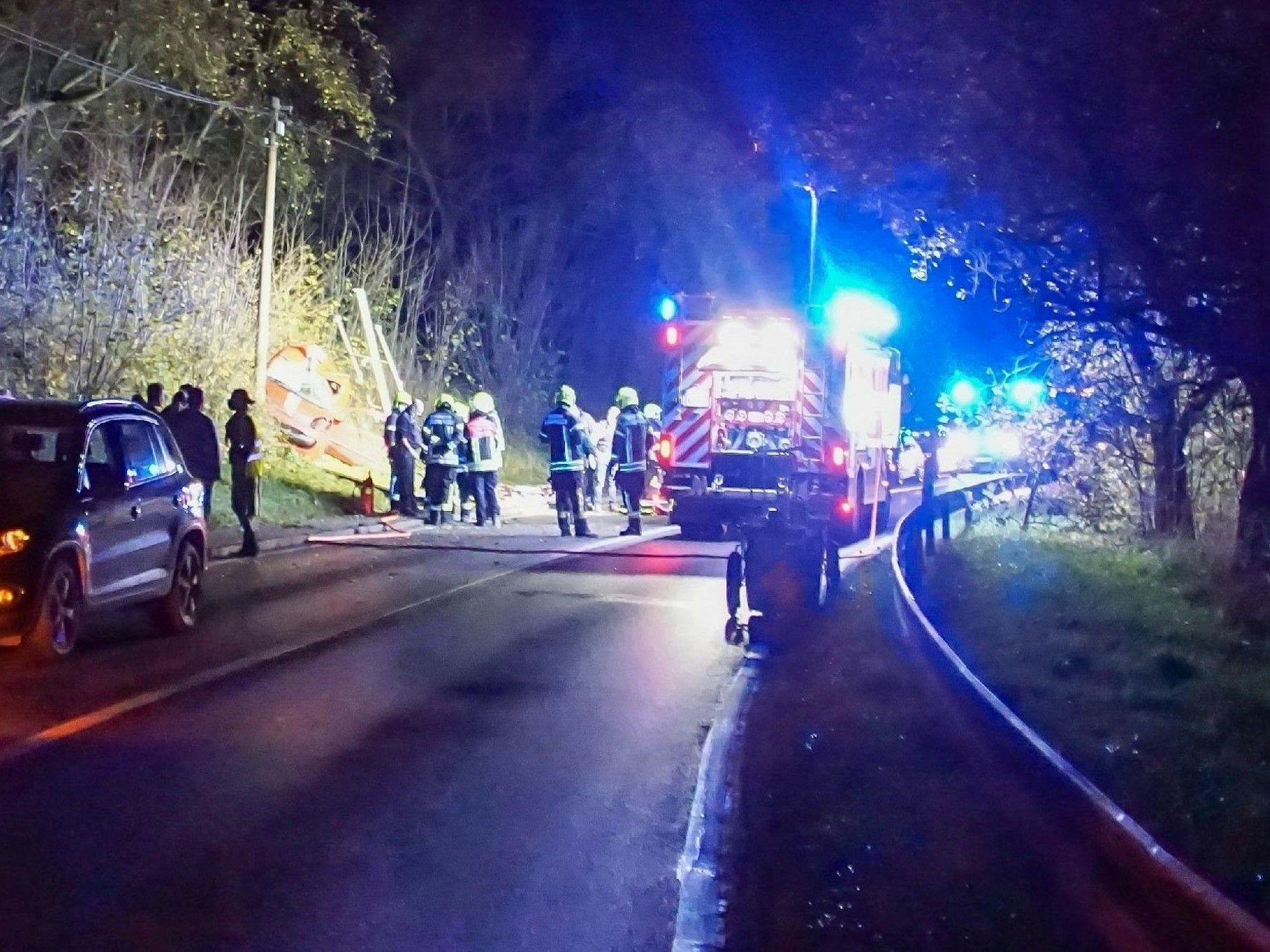 Feuerwehrleute sind nach einem Unfall auf einer Landstraße im Einsatz.