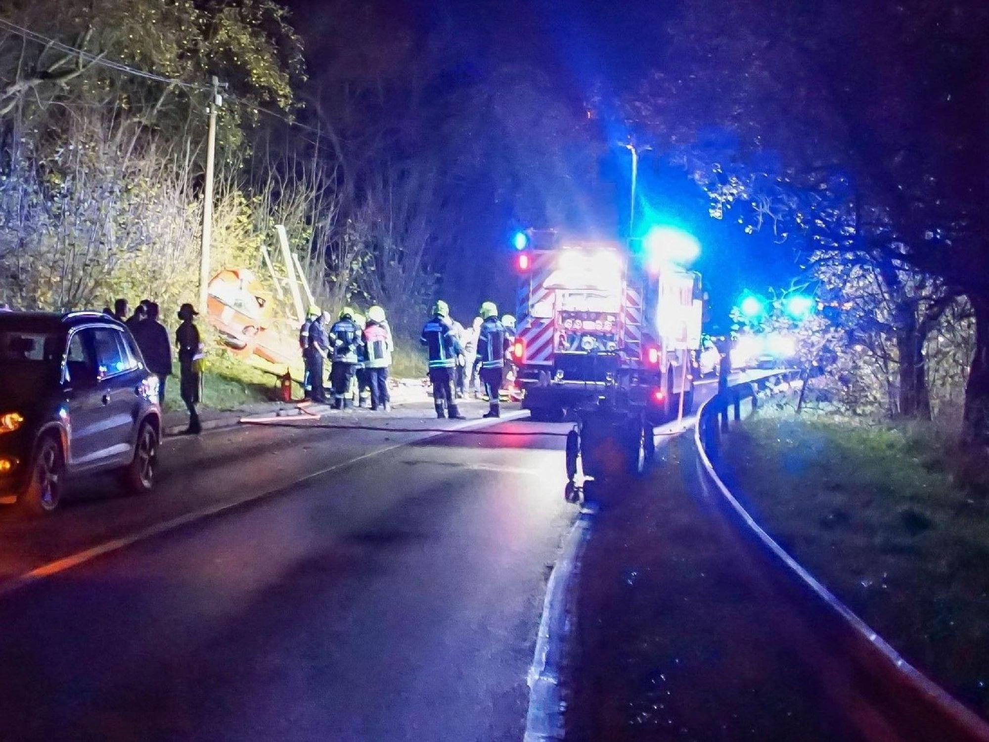 Feuerwehrleute sind nach einem Unfall auf einer Landstraße im Einsatz.