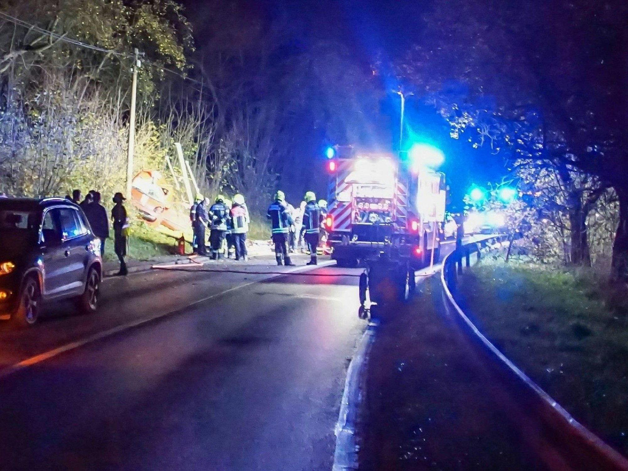 Feuerwehrleute sind nach einem Unfall auf einer Landstraße im Einsatz.