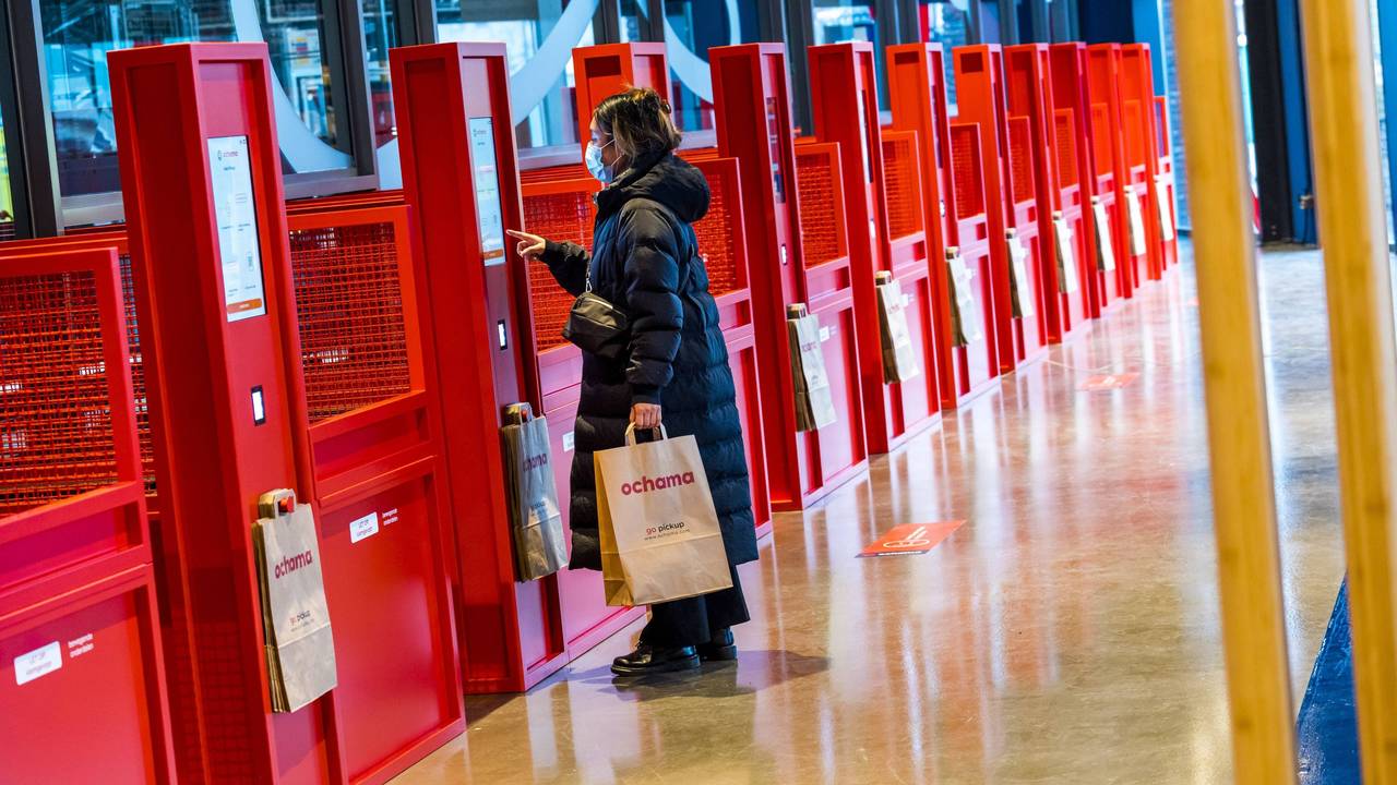 Eine Kundin lässt sich in Rotterdam ihren QR-Code in einer roten Abholstelle des chinesischen Supermarkts Ochama scannen.
