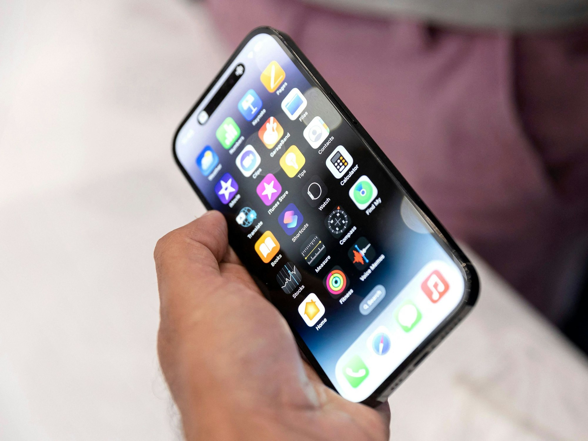Ein Apple-Mitarbeiter hält in unserem Archivbild (2022) eines der damals vorgestellten iPhone-Pro-Modell während des Launch-Events im Apple-Hauptquartier in Cupertino (Kalifornien) in der Hand: Apple versucht, seine Abhängigkeit von China zu minimieren.