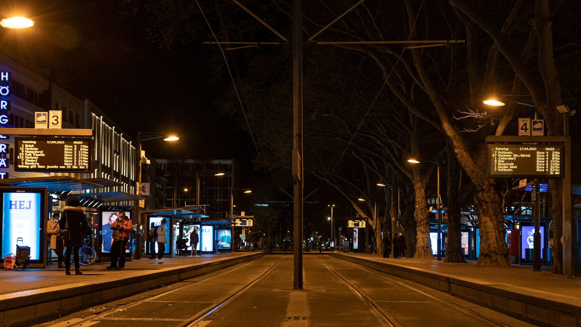 Nächtlicher Blick auf die Haltestelle Neumarkt in Köln. An beiden Seiten der Gleise sind Anzeigetafeln zu sehen.