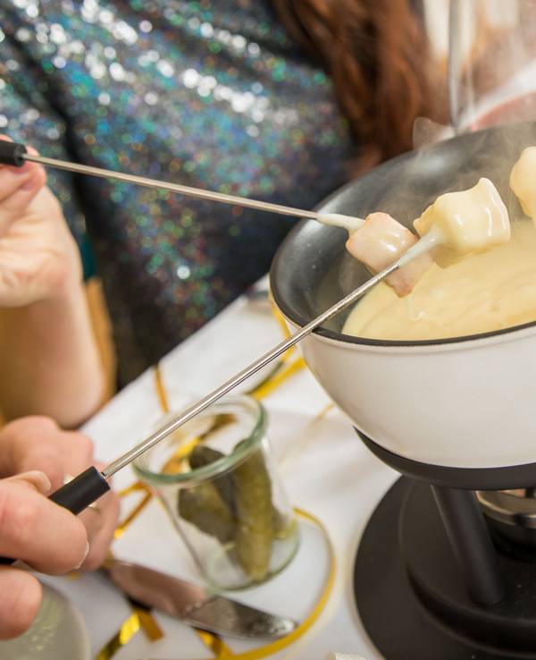 Ein Käsefondue-Set steht auf dem Tisch.