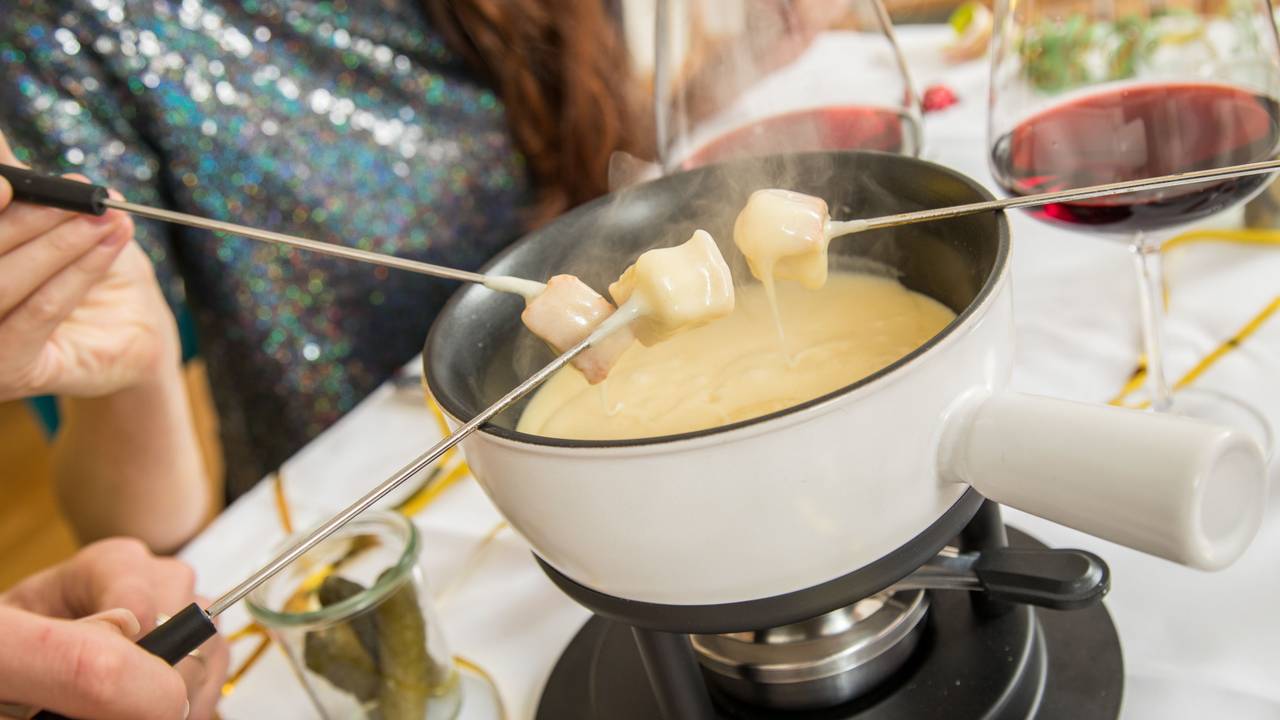 Ein Käsefondue-Set steht auf dem Tisch.