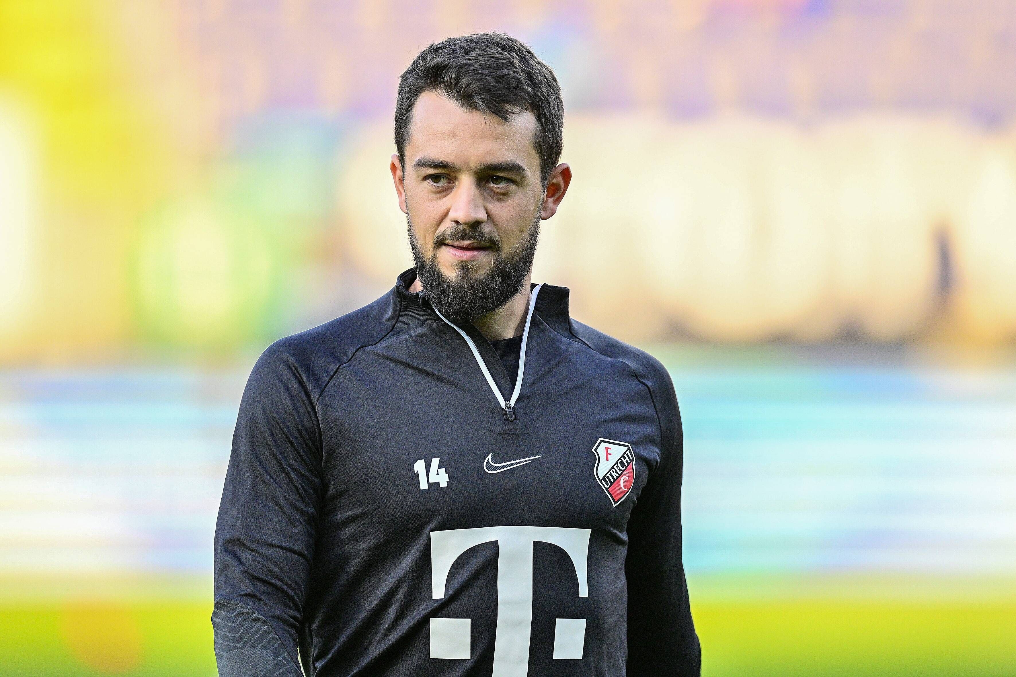 Amin Younes geht vor einem Spiel des FC Utrecht im Trainings-Pullover über den Platz