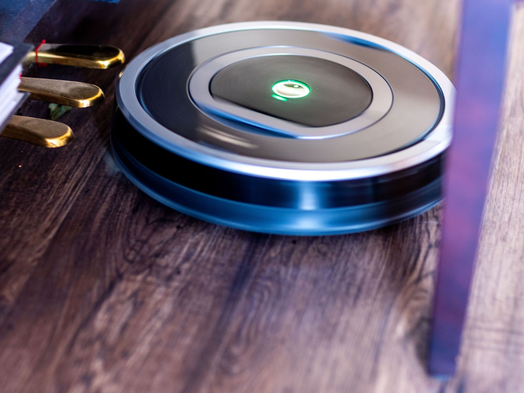 Ein Saugroboter fährt durch eine Wohnung und reinigt den Fußboden.