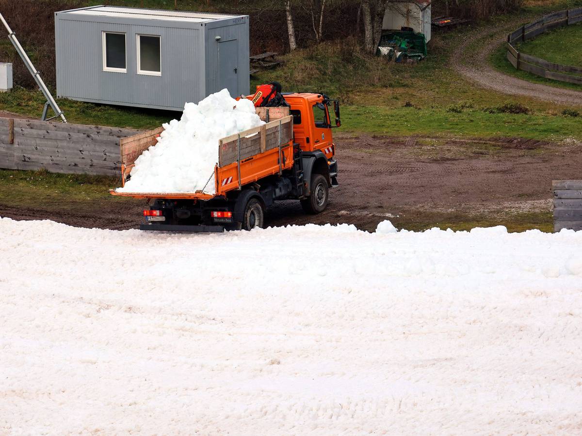 Ein Lastwagen kippt Altschnee in den Schanzenauslauf.