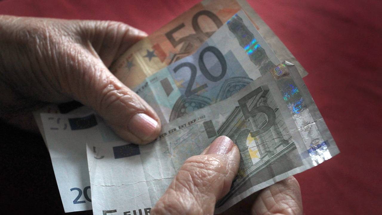 Eine ältere Frau hält verschiedene Euronoten in der Hand.