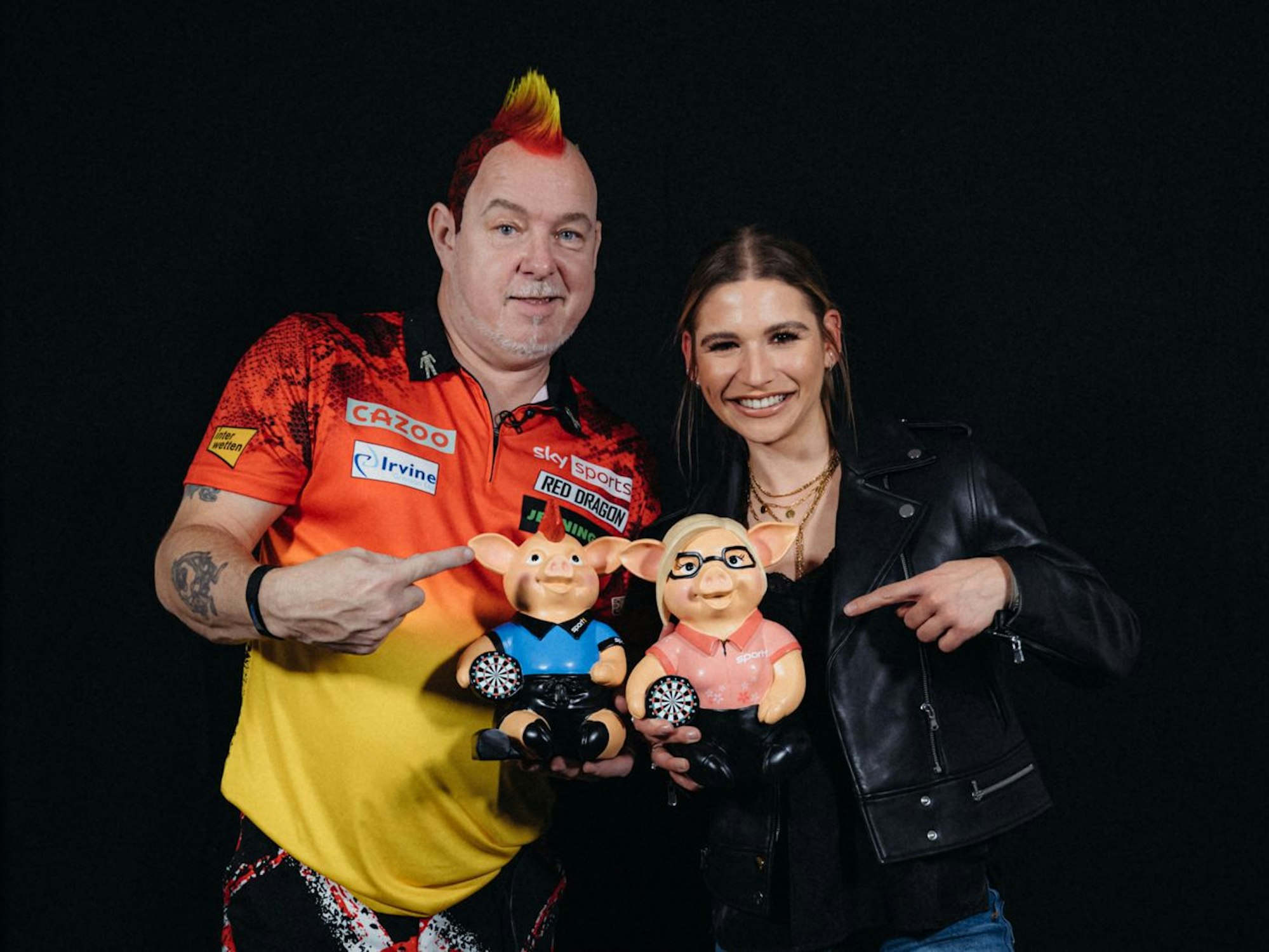 WM-Titelverteidiger Peter Wright (l.) aus Schottland posiert mit Sport1-Moderatorin Jana Wosnitza.