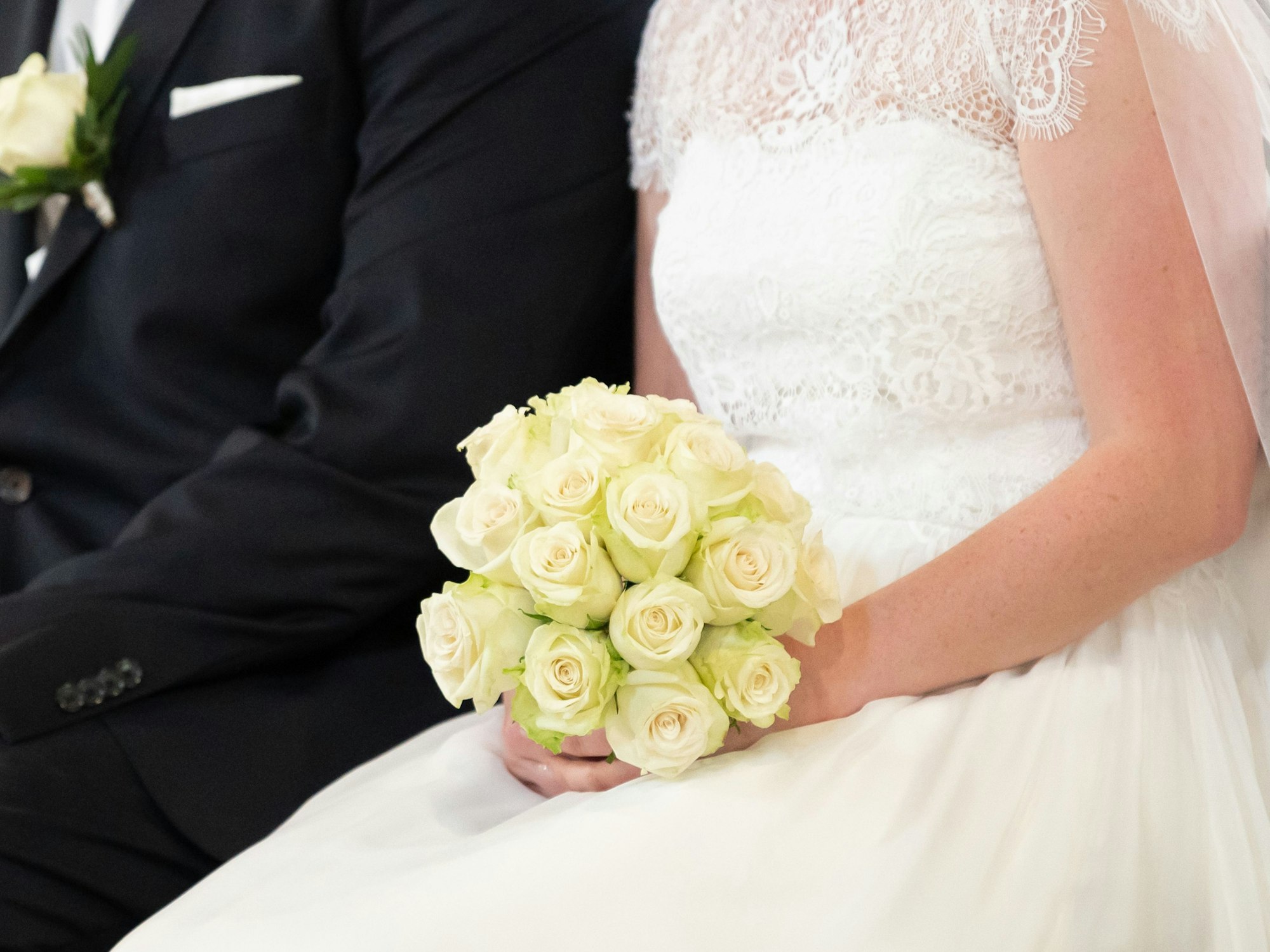 Ein Brautpaar sitzt während ihrer Trauung in der Kirche.