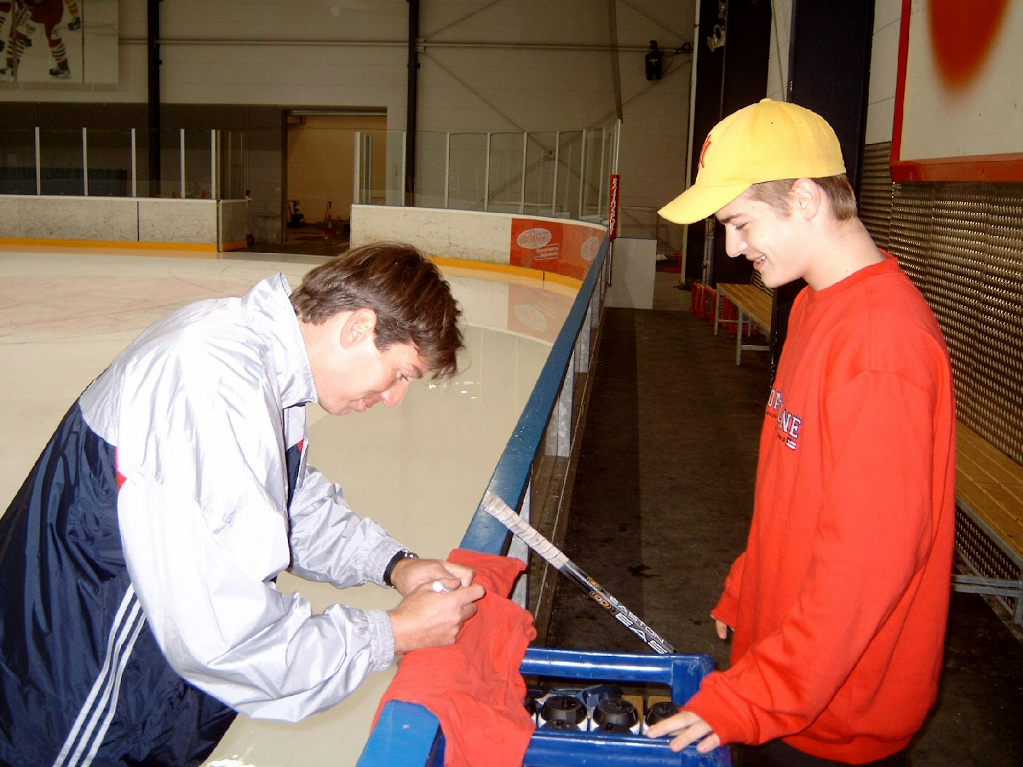 Eishockey-Legende Uwe Krupp unterschreibt ein Shirt von Moritz Müller (Kölner Haie).