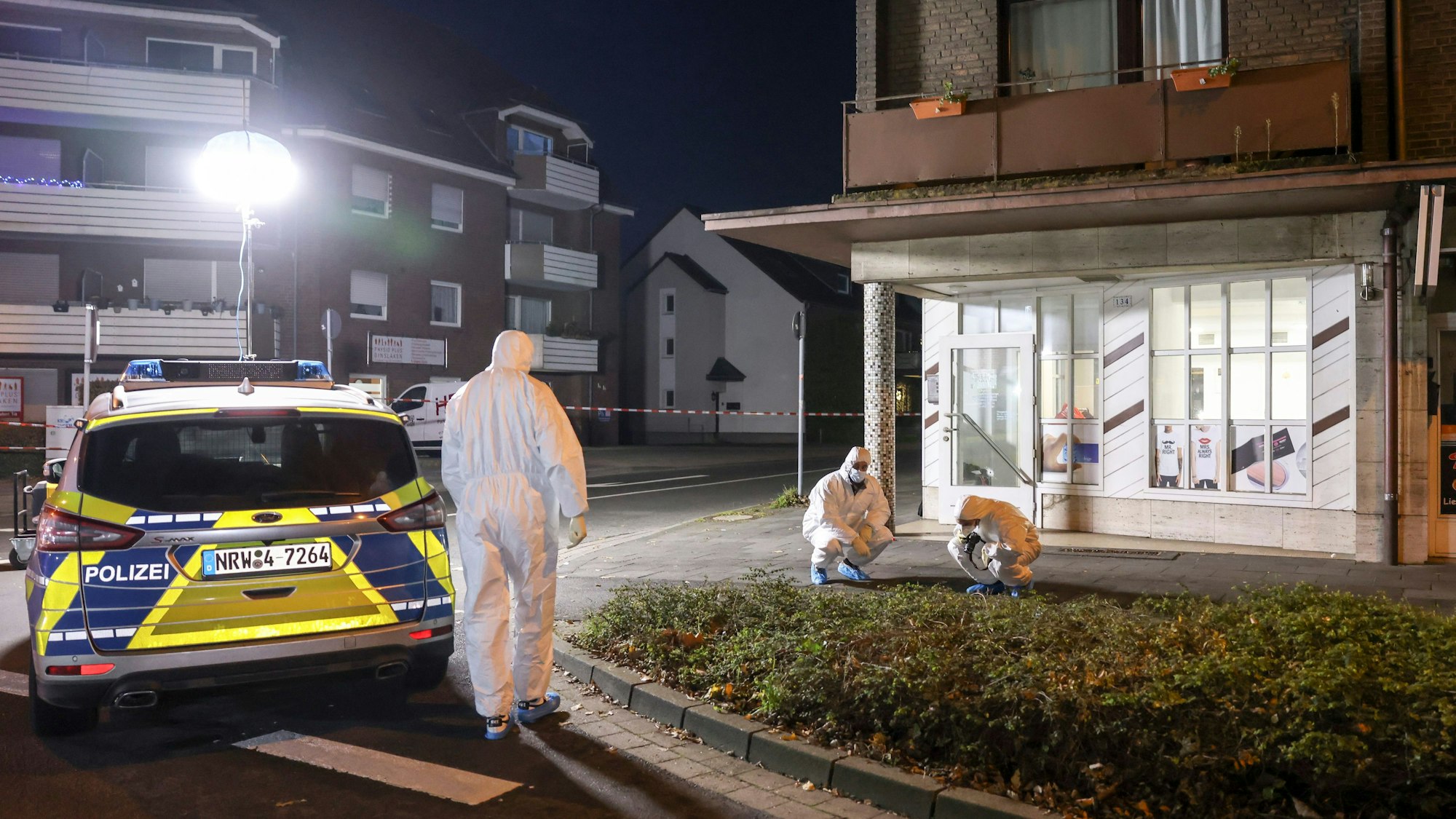 Drei Personen in Schutzanzügen sichern Spuren am Tatort.