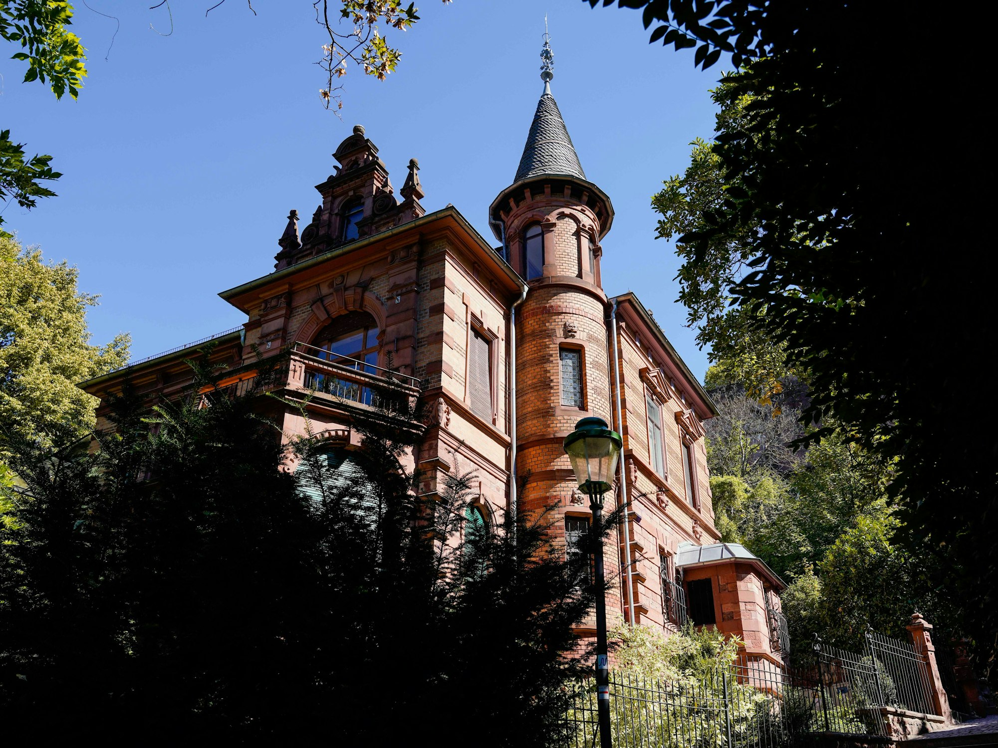 Blick auf das Haus der Burschenschaft Normannia, welches umrandet ist von Bäumen.