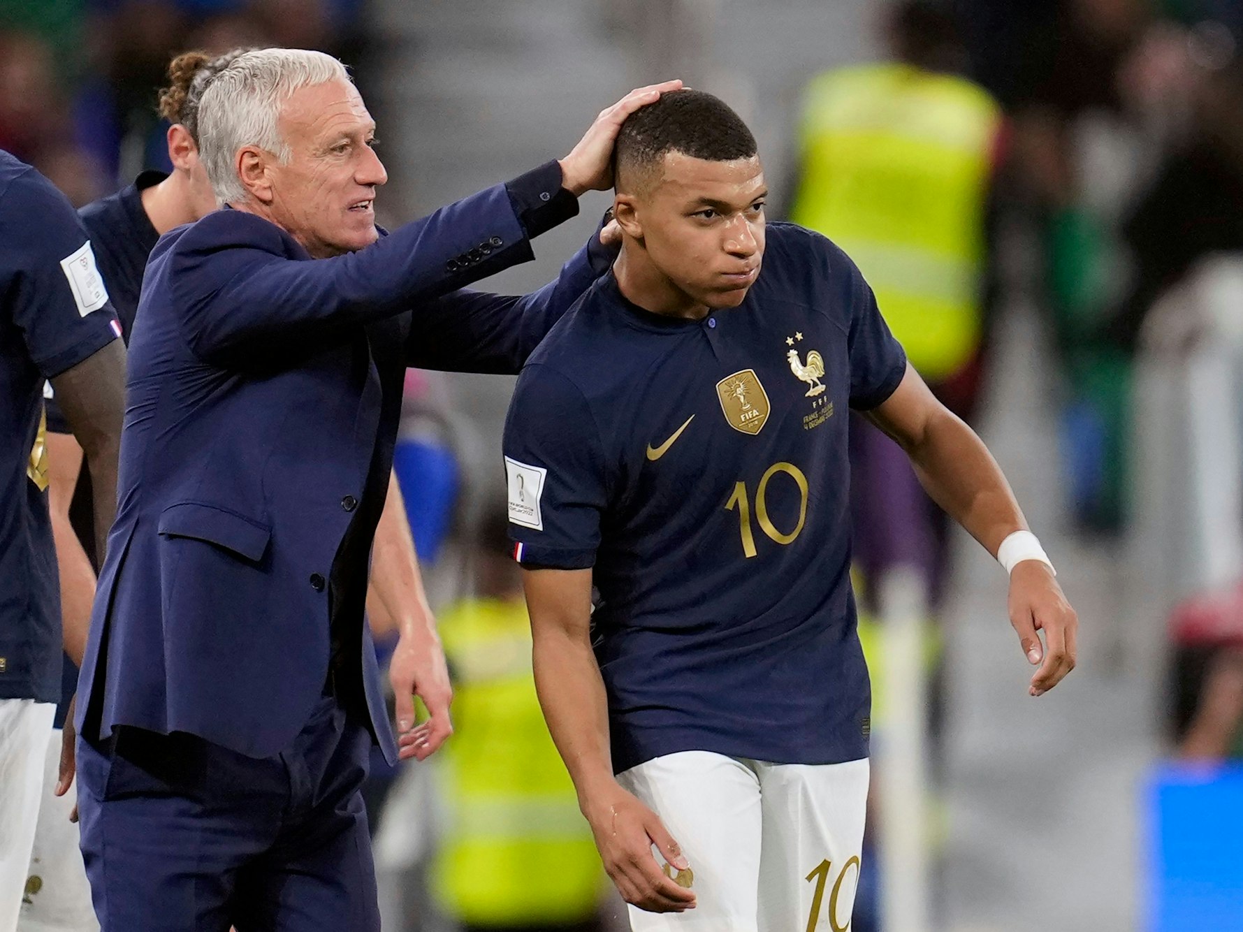 Trainer Didier Deschamps klopft Kylian Mbappe auf seinen Kopf.