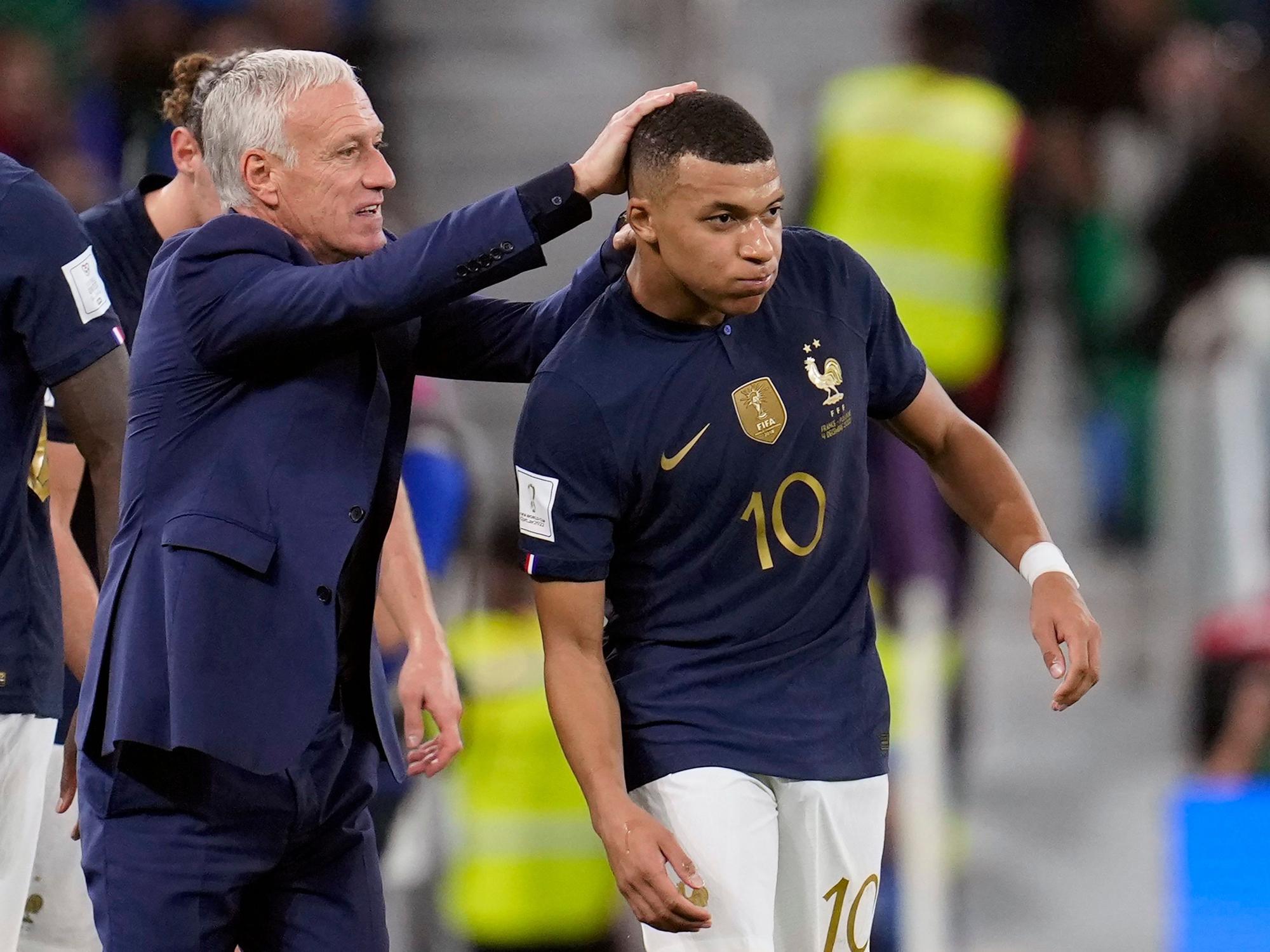 Trainer Didier Deschamps klopft Kylian Mbappe auf seinen Kopf.