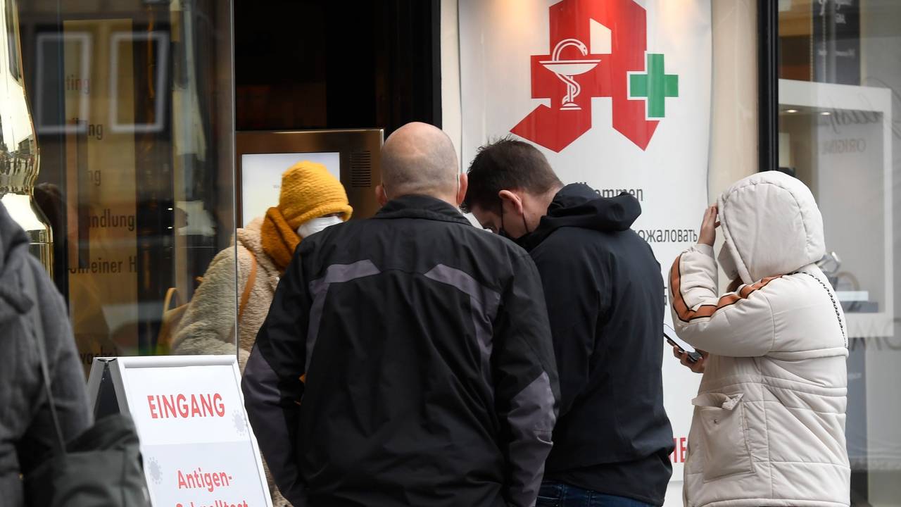 Menschen stehen vor einer Apotheke Schlange.