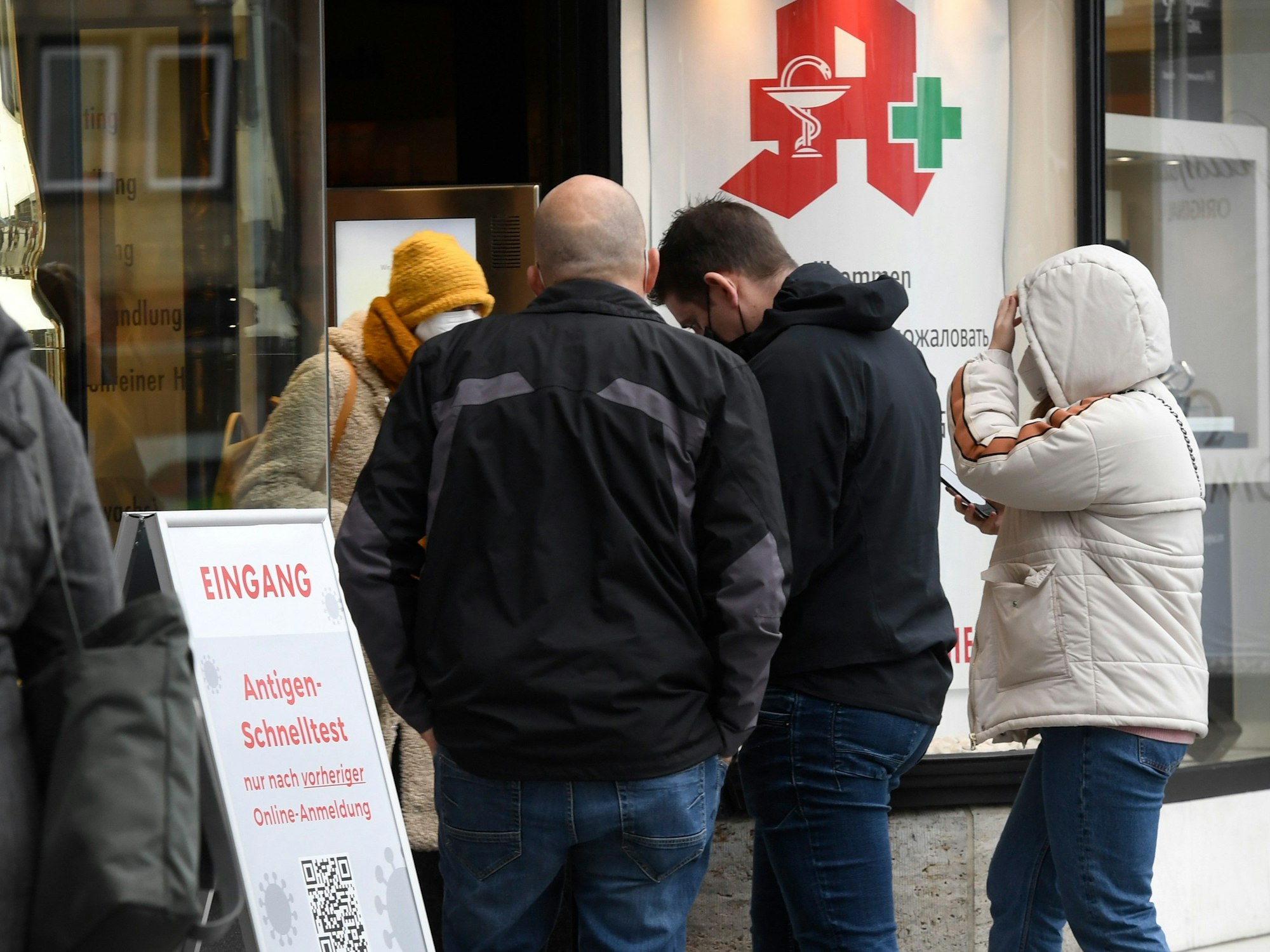 Menschen stehen vor einer Apotheke Schlange.