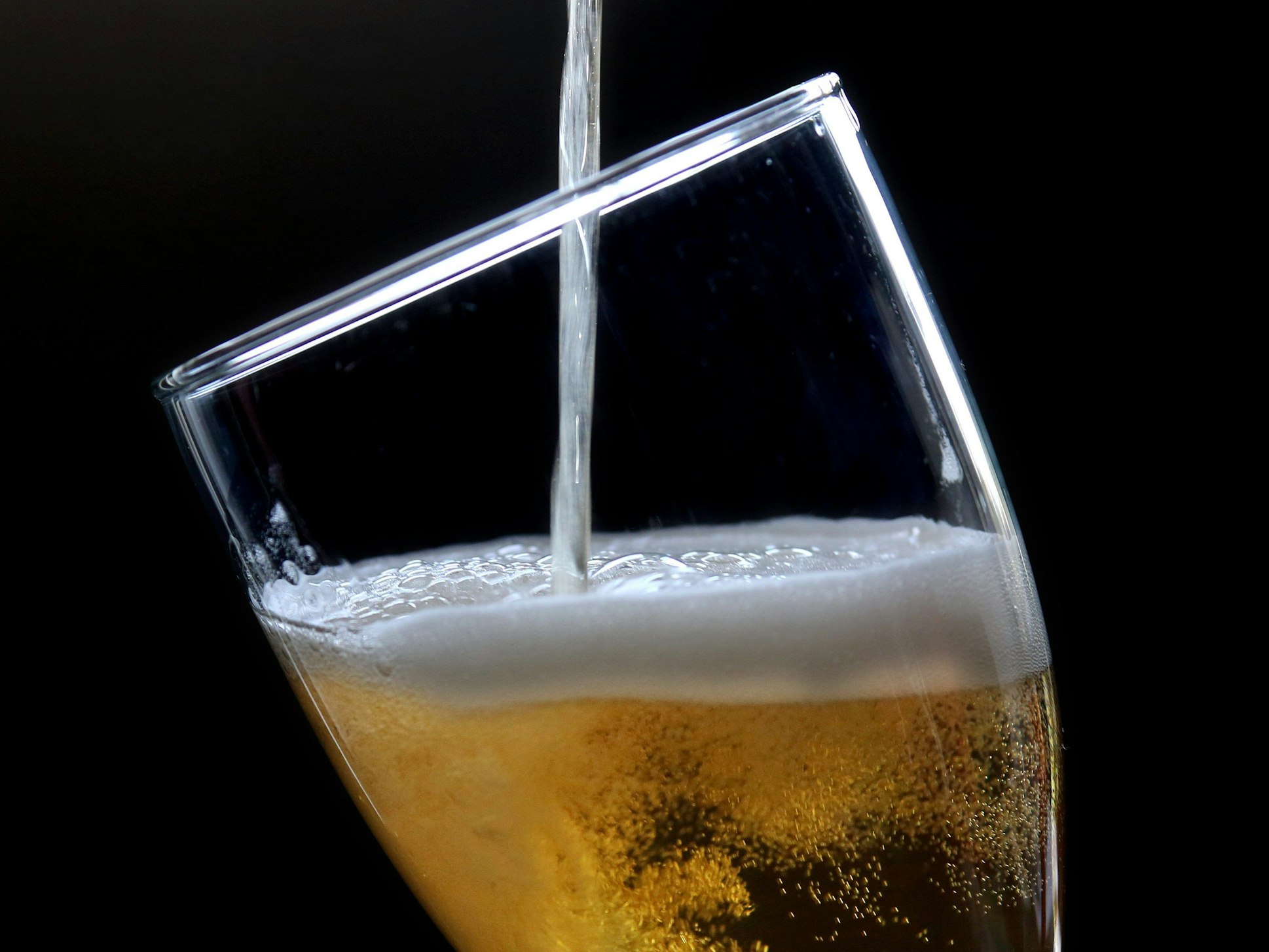 Ein Bier wird in ein Glas gezapft.