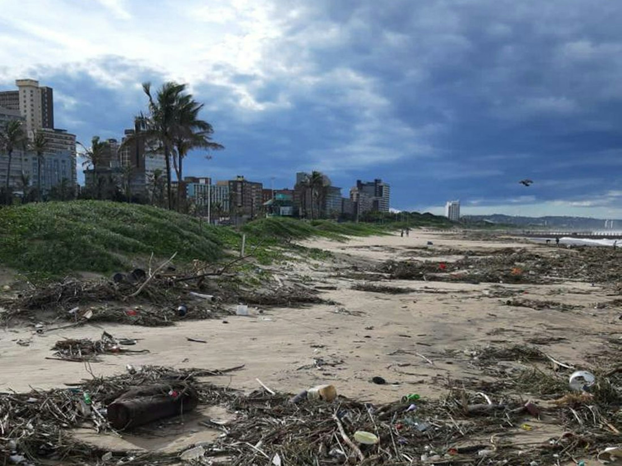 Dunkle Wolken ziehen über den Strand hinweg, wo nach ungewöhnlich heftigen Niederschlägen reichlich Unrat angespült wurde.