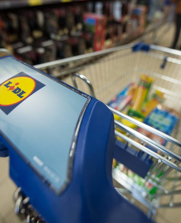 Ein Kunde schiebt in einer Filiale des Lebensmitteldiscounters Lidl einen Einkaufswagen durch die Regalreihen.