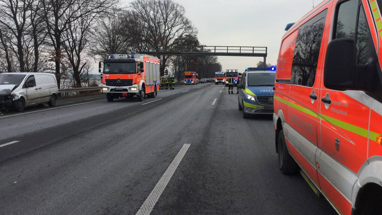 Einsatzfahrzeuge von Feuerwehr, Rettungsdienst und Polizei stehen auf der Autobahn, auf dem Standstreifen ein am Unfall beteiligtes Fahrzeug.