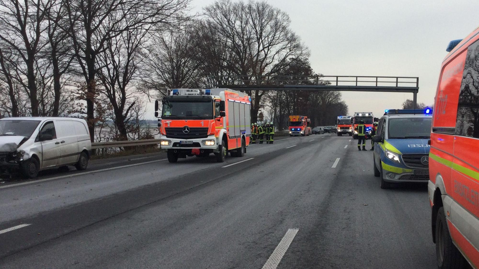 Einsatzfahrzeuge von Feuerwehr, Rettungsdienst und Polizei stehen auf der Autobahn, auf dem Standstreifen ein am Unfall beteiligtes Fahrzeug.