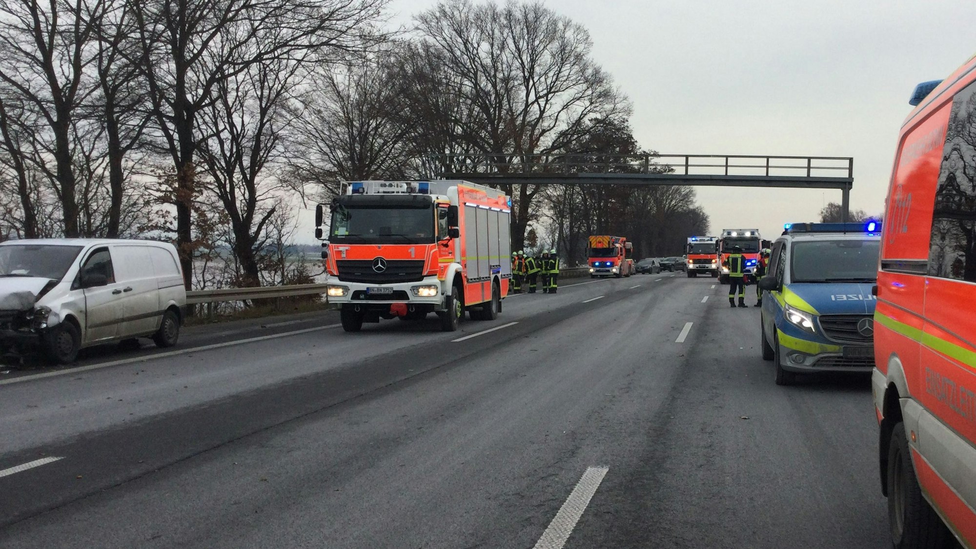 Einsatzfahrzeuge von Feuerwehr, Rettungsdienst und Polizei stehen auf der Autobahn, auf dem Standstreifen ein am Unfall beteiligtes Fahrzeug.