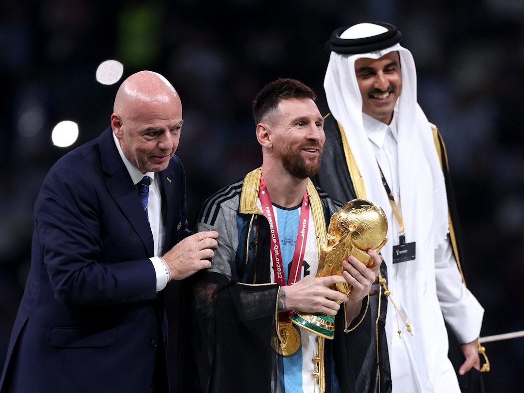 Lionel Messi steht bei der Siegerehrung mit dem WM-Pokal neben Fifa-Präsident Gianni Infantino und Katars Emir Tamim bin Hamad Al Thani.