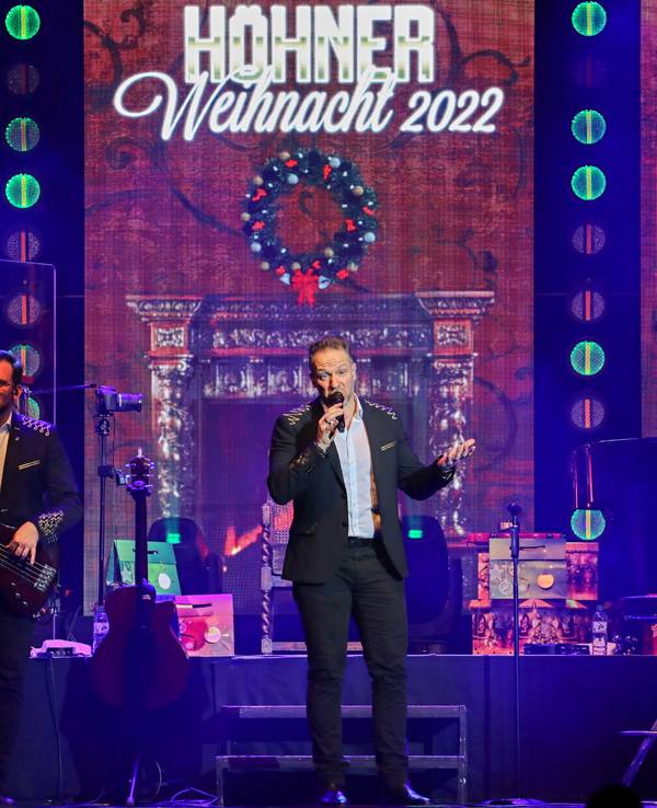 Sänger Patrick Lück steht mit einem Mikrofon auf einer Bühne.