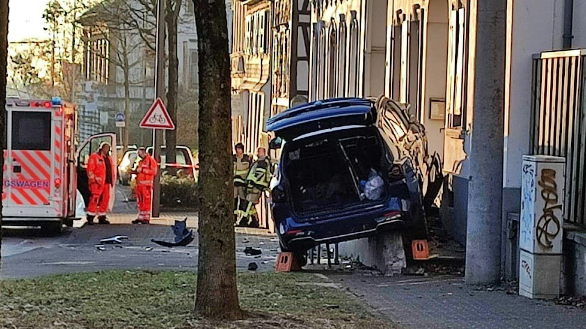 Nach einem Unfall hängt ein stark beschädigtes Auto auf der Treppe zu einem Haus fest.