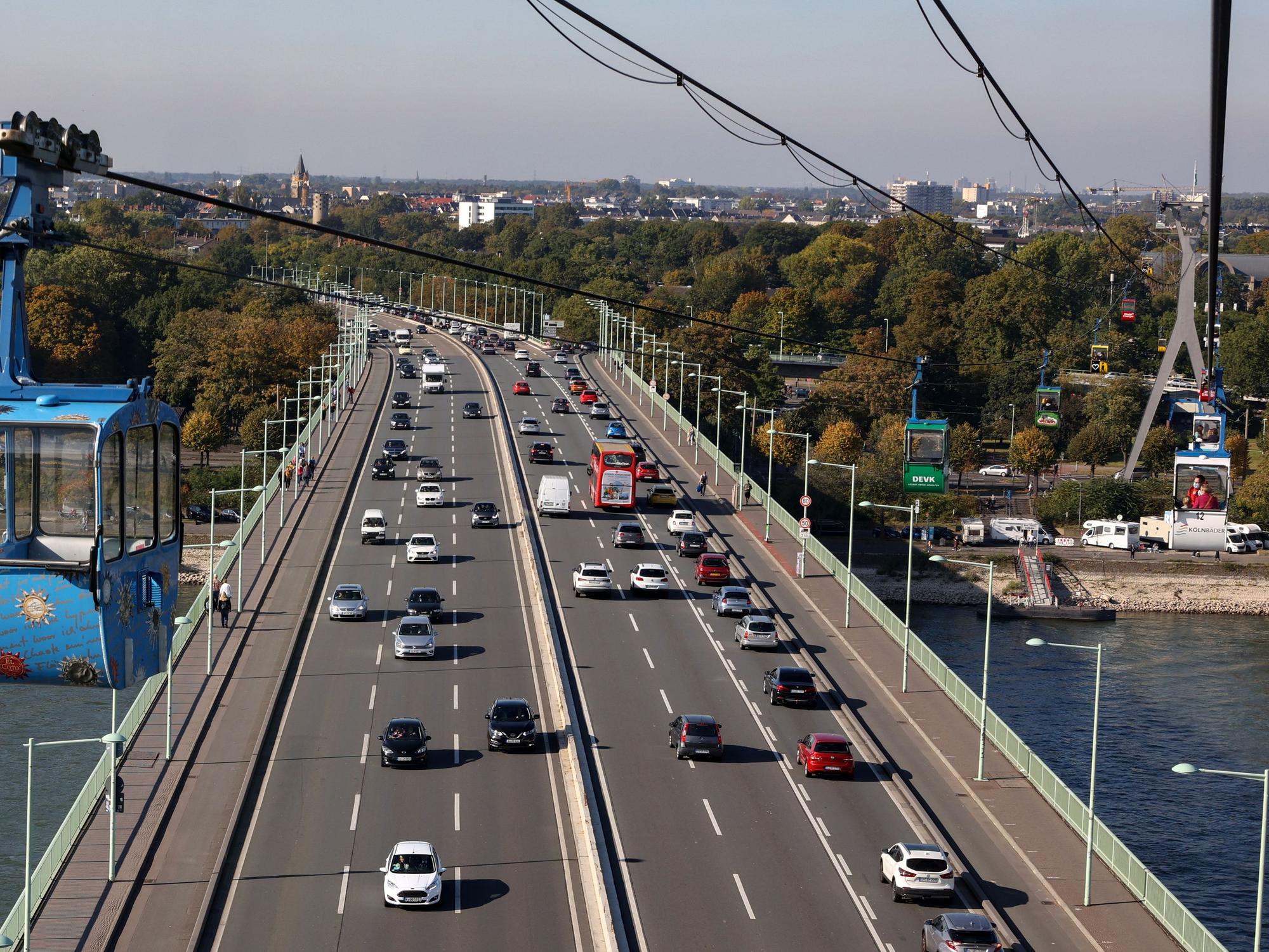 Autos fahren über die Zoobrücke in Köln. Im Vordergrund ist die Kölner Seilbahn zu sehen.
