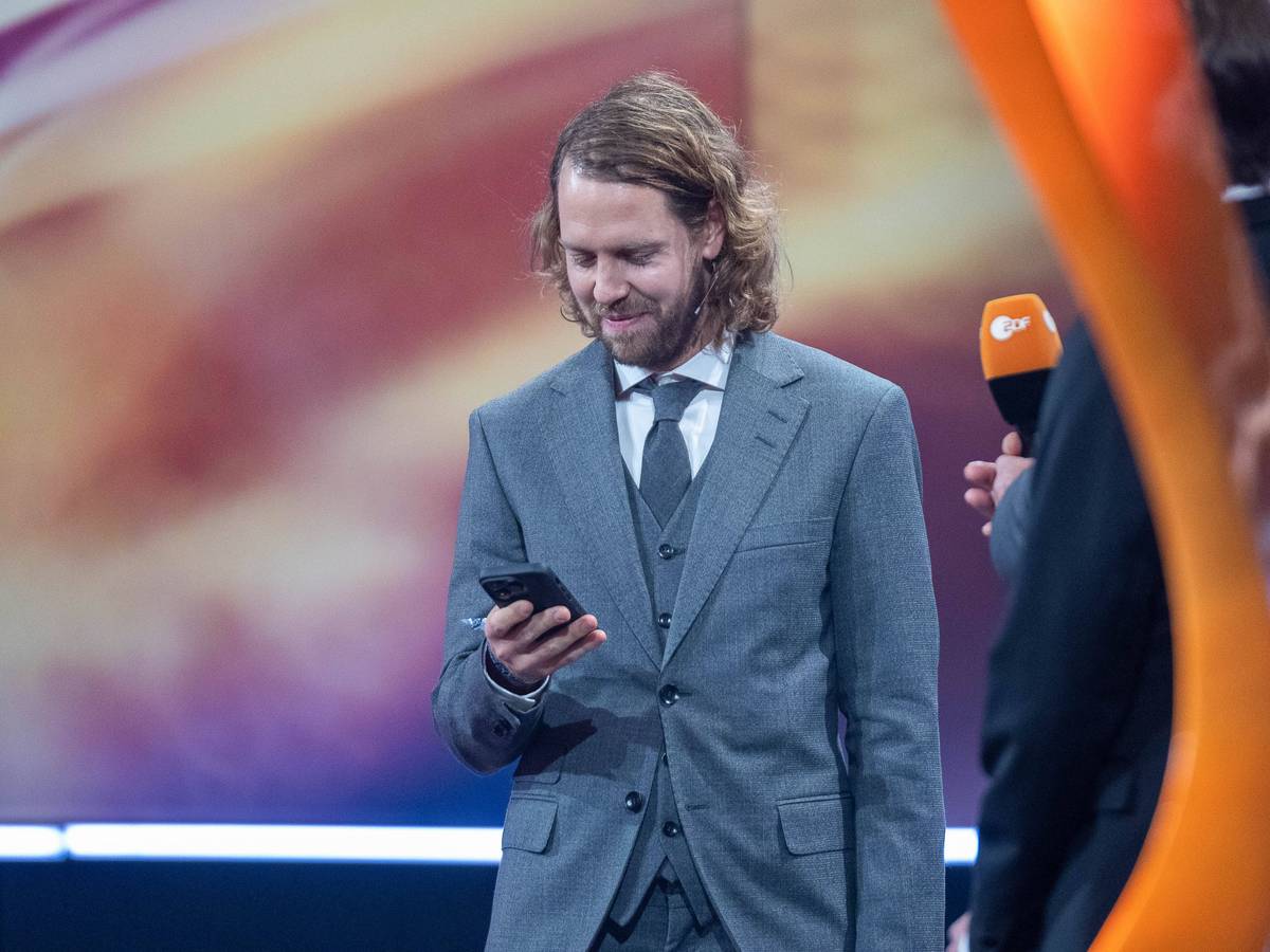 Sebastian Vettel schaut auf sein Handy.