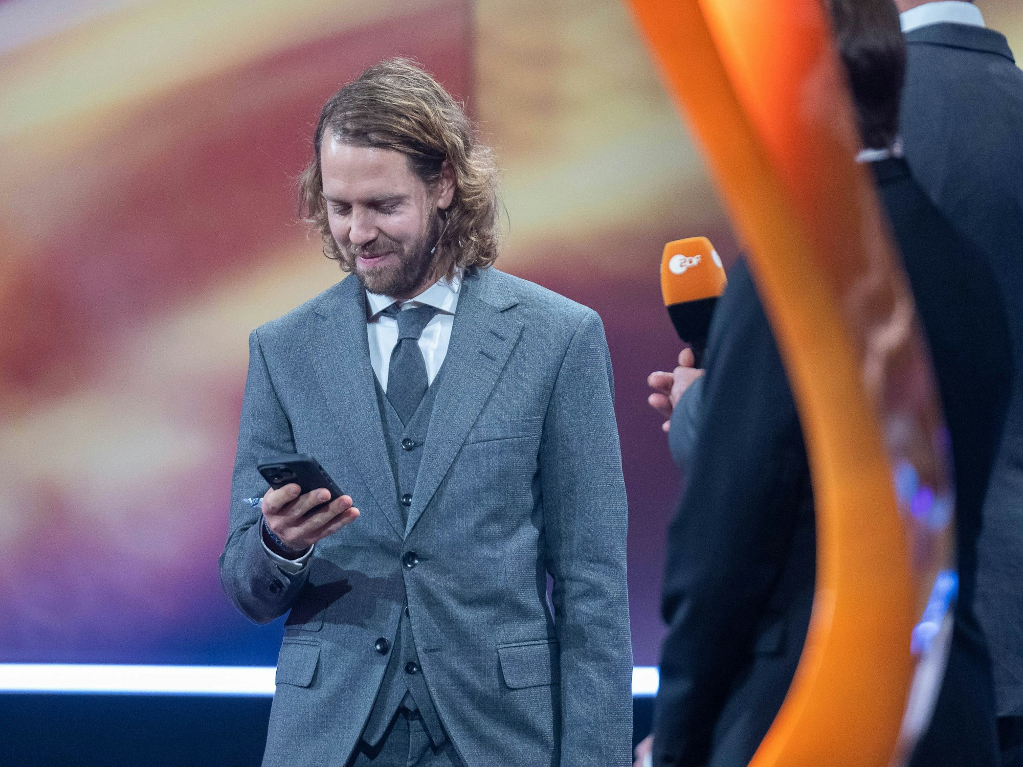 Sebastian Vettel schaut auf sein Handy.