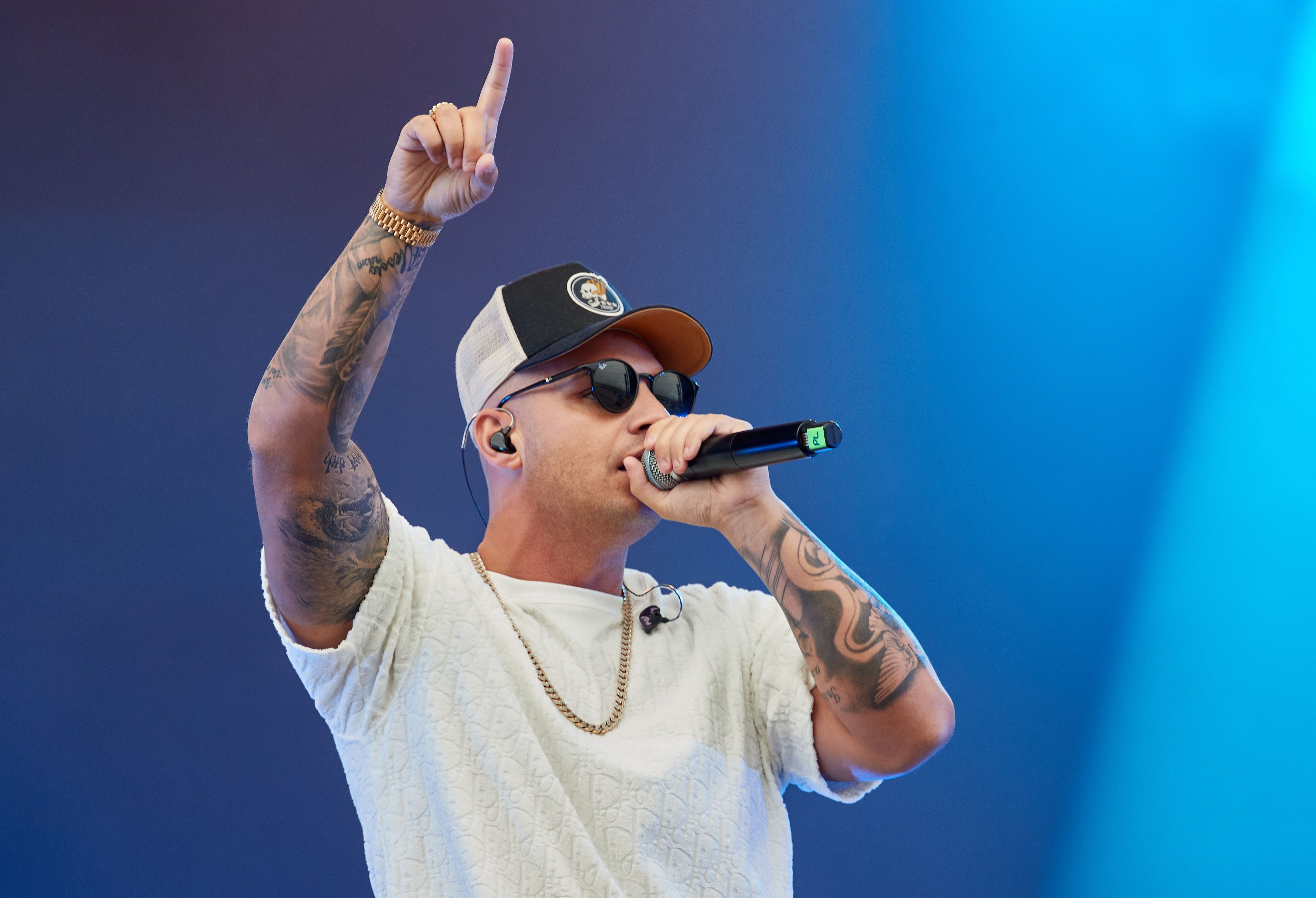 Pietro Lombardi steht auf der Bühne beim Strandkorb Open Air-Konzert am Cruise Center Steinwerder. Wie gewohnt trägt er Cap und Sonnenbrille.