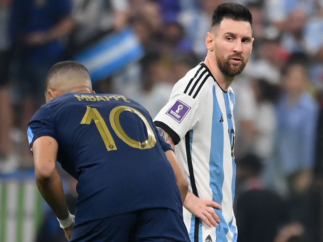 Lionel Messi blickt Kylian Mbappé im WM-Finale an, der richtet sich gerade seine Stutzen.