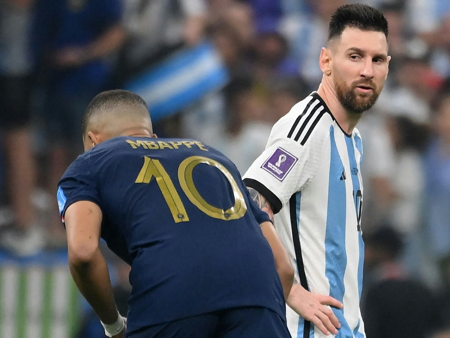 Lionel Messi blickt Kylian Mbappé im WM-Finale an, der richtet sich gerade seine Stutzen.