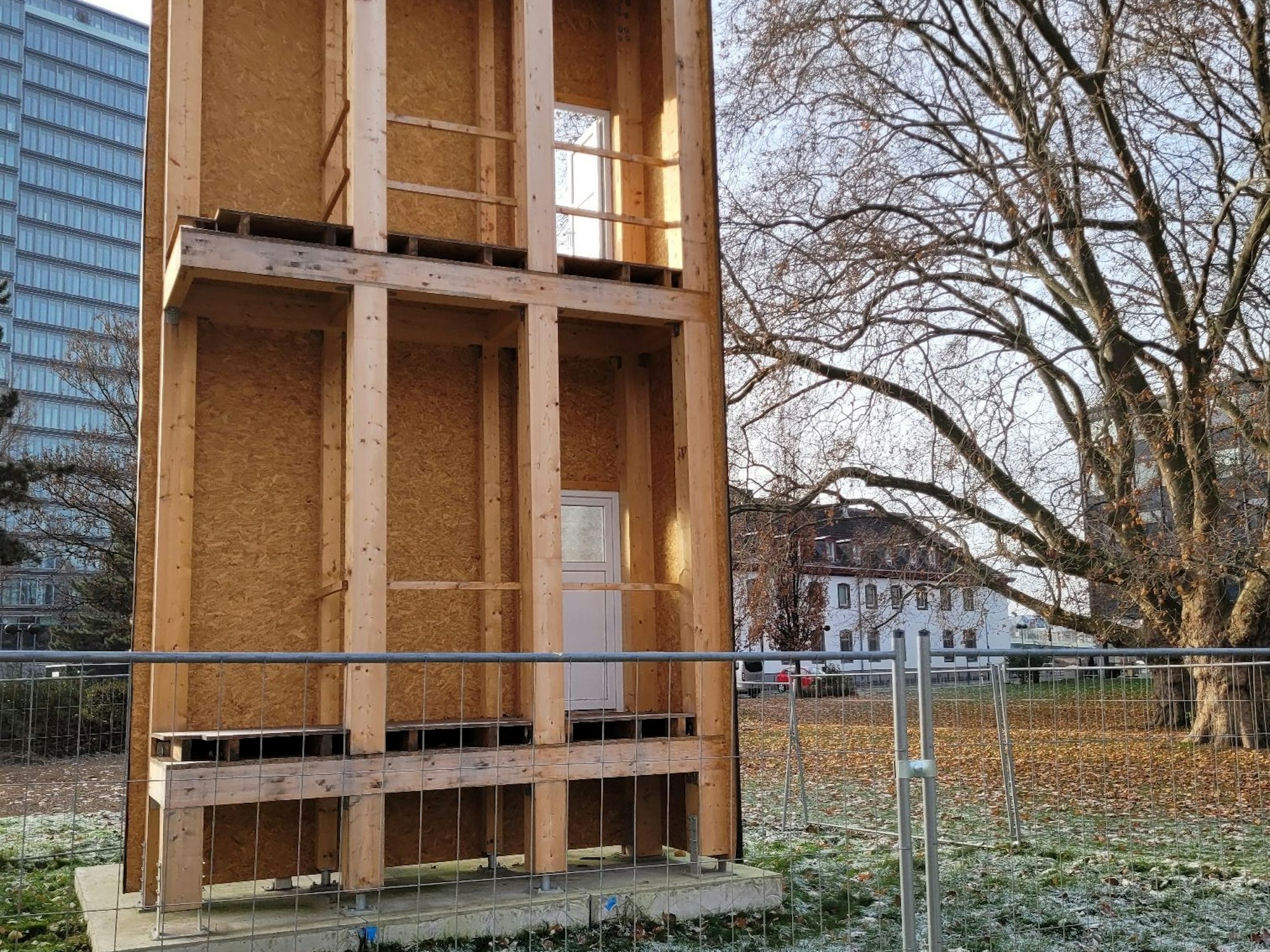 Kleines Bauwerk aus Holz steht auf einer Wiese in Köln-Deutz. Hier baut der LVR sein neues Gebäude.