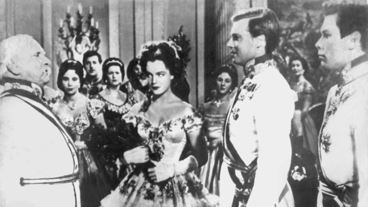 Die Schauspielerin Romy Schneider als Kaiserin Elisabeth (M) und der Theater- und Filmschauspieler Karlheinz Böhm als ihr Gatte Kaiser Franz Joseph von Österreich (2.v.r.) in einer Szene der "Sissi"-Filmtrilogie.