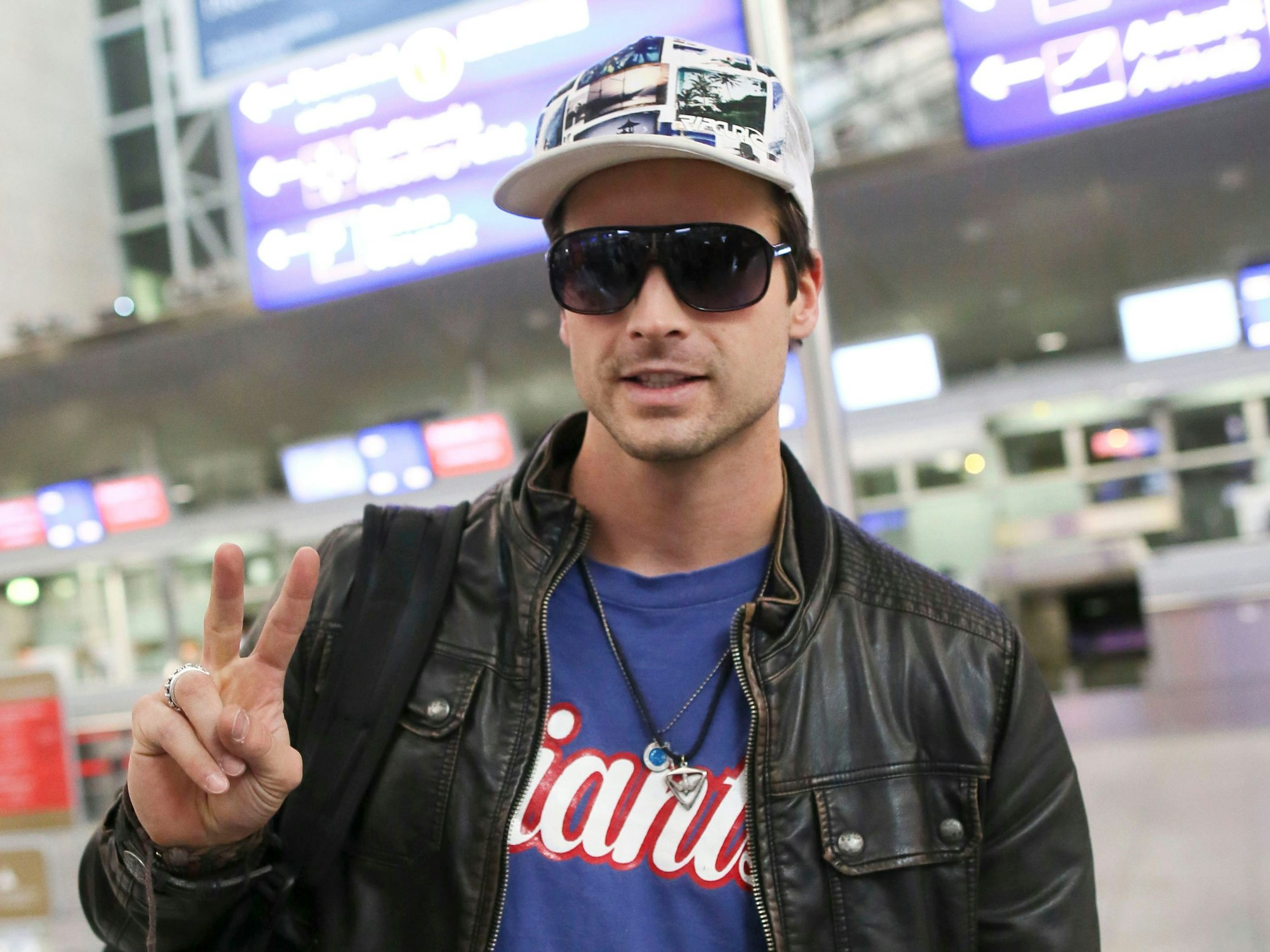 Der Sänger Patrick Nuo macht am Flughafen ein Peace-Zeichen in die Kamera, kurz vor seinem Abflug nach Australien.