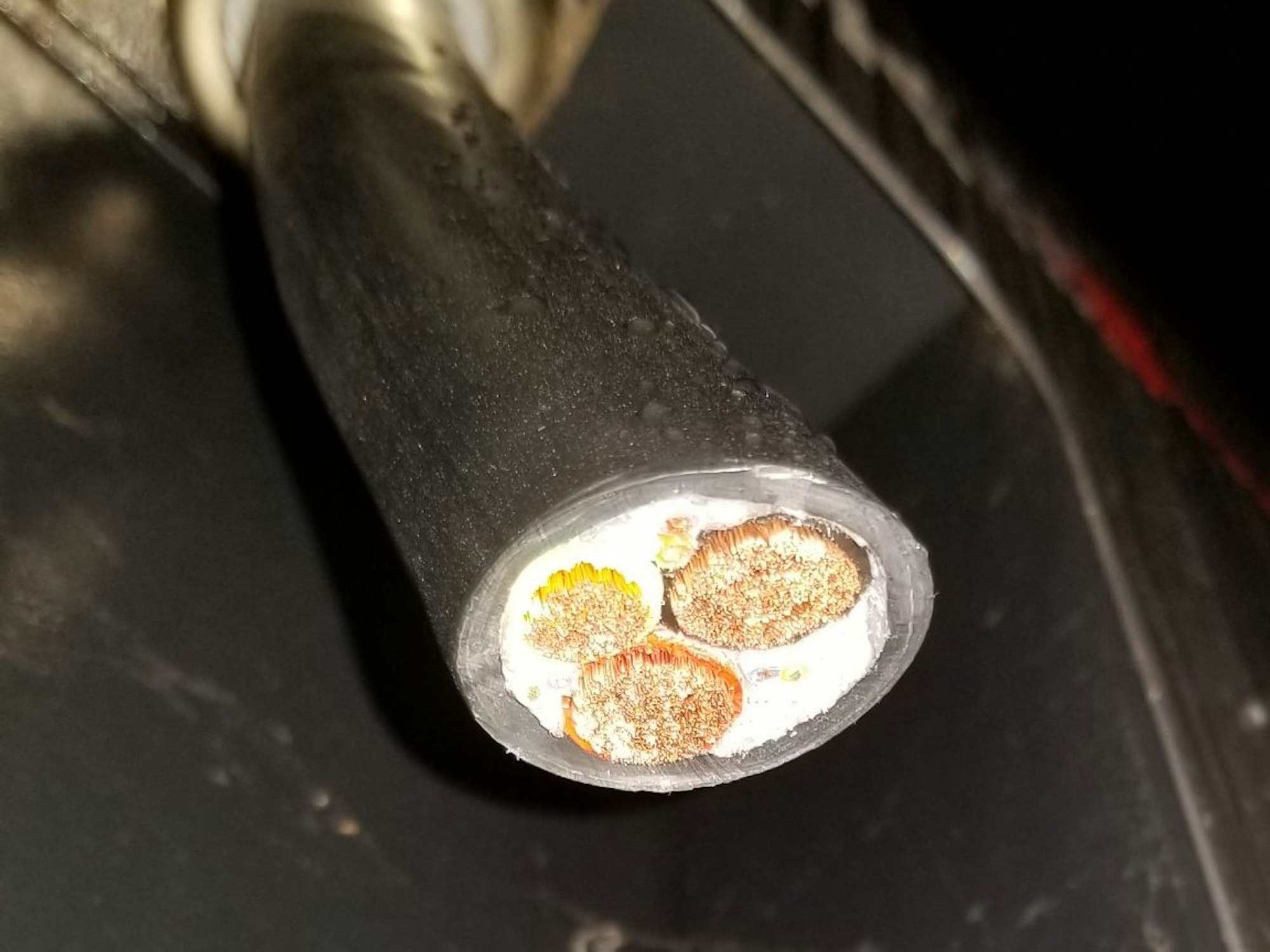 Ein abgeschnittenes Kabel einer Ladestation für E-Fahrzeuge