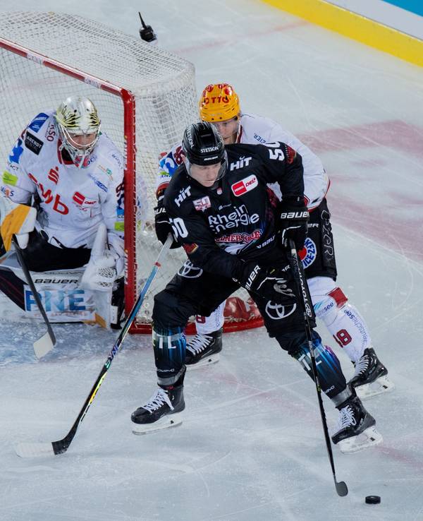 Kölns Alexander Oberlinger (vorne) und Braunschweigs Nicholas Jensen versuchen an den Puck zu kommen.