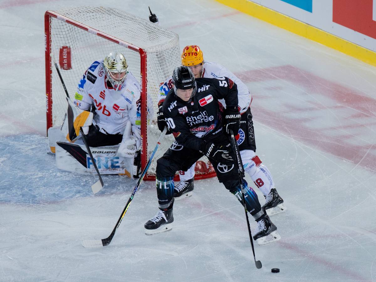 Kölns Alexander Oberlinger (vorne) und Braunschweigs Nicholas Jensen versuchen an den Puck zu kommen.