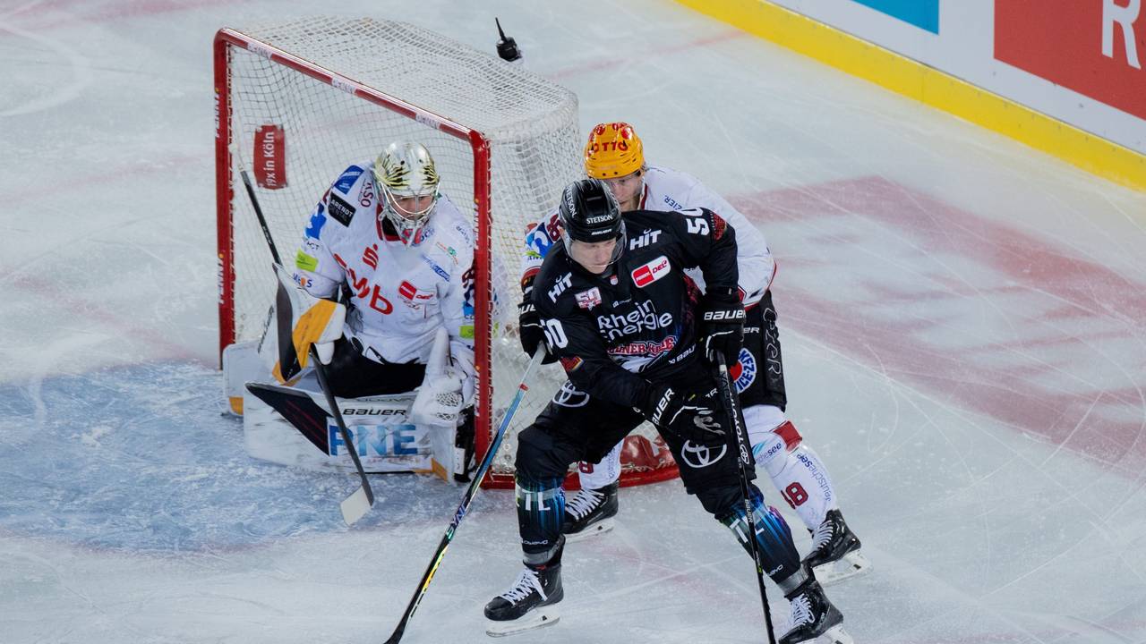 Kölns Alexander Oberlinger (vorne) und Braunschweigs Nicholas Jensen versuchen an den Puck zu kommen.