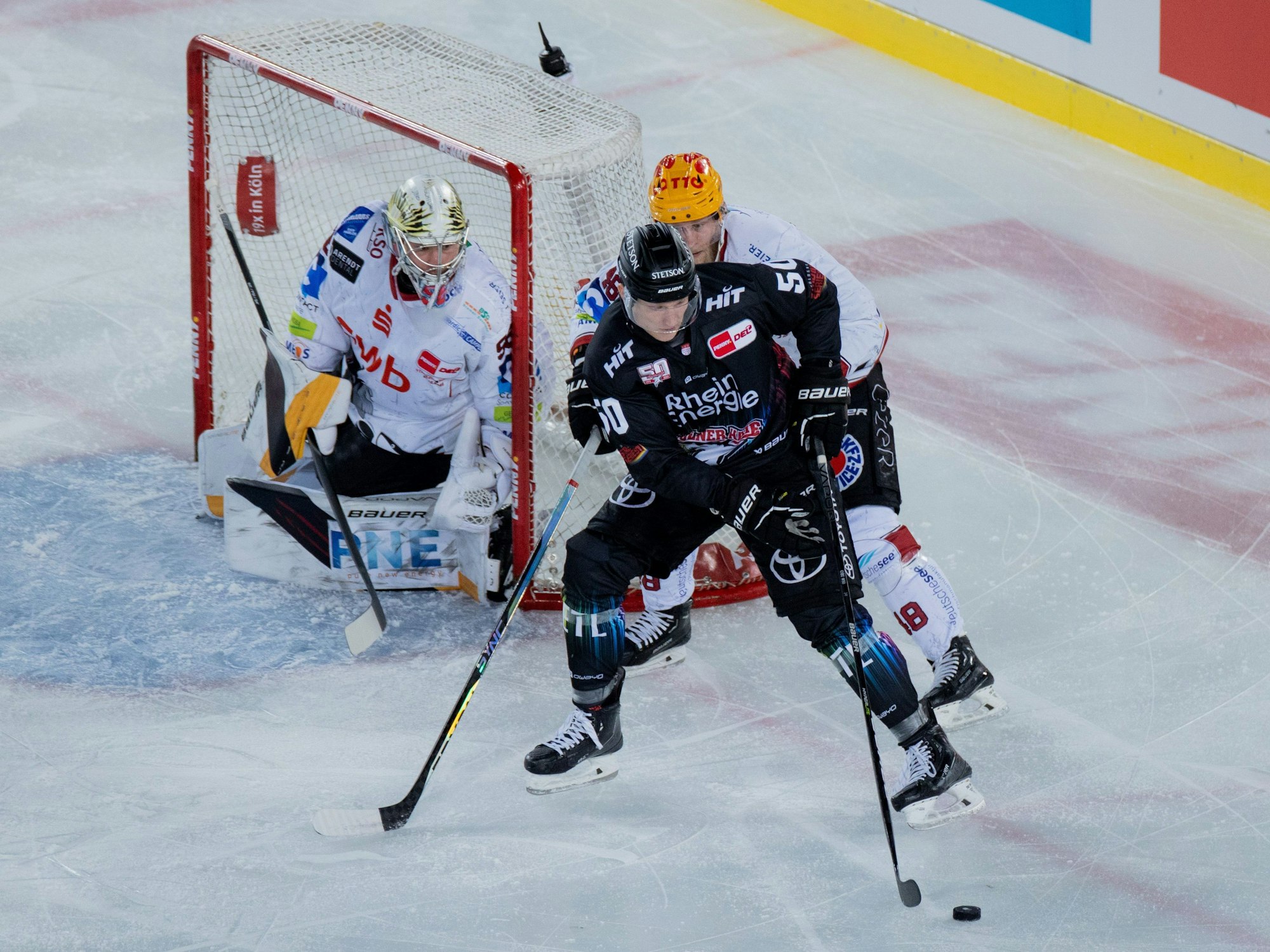 Kölns Alexander Oberlinger (vorne) und Braunschweigs Nicholas Jensen versuchen an den Puck zu kommen.