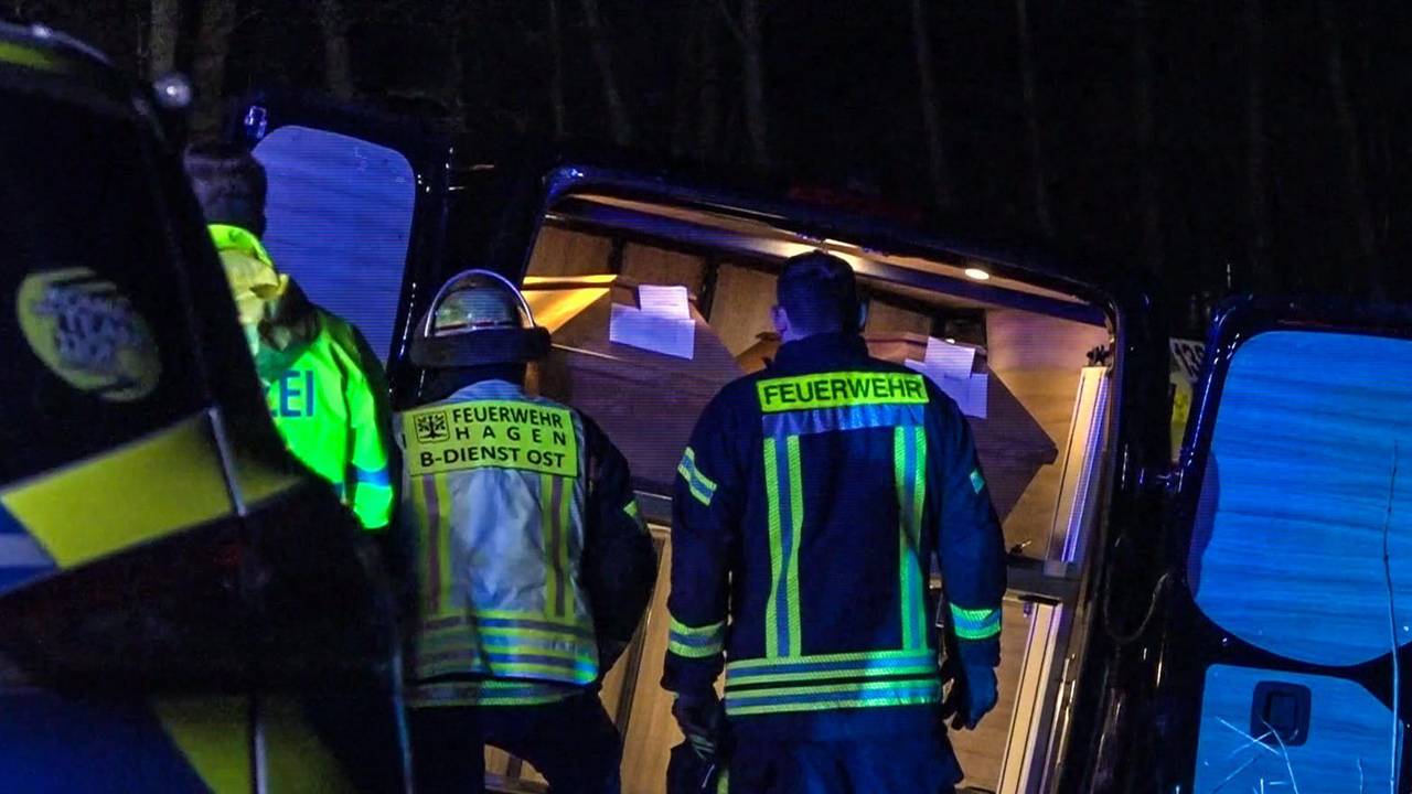 Einsatzkräfte stehen am 21. Dezember 2022 vor einem verunglückten Leichenwagen in Hagen.
