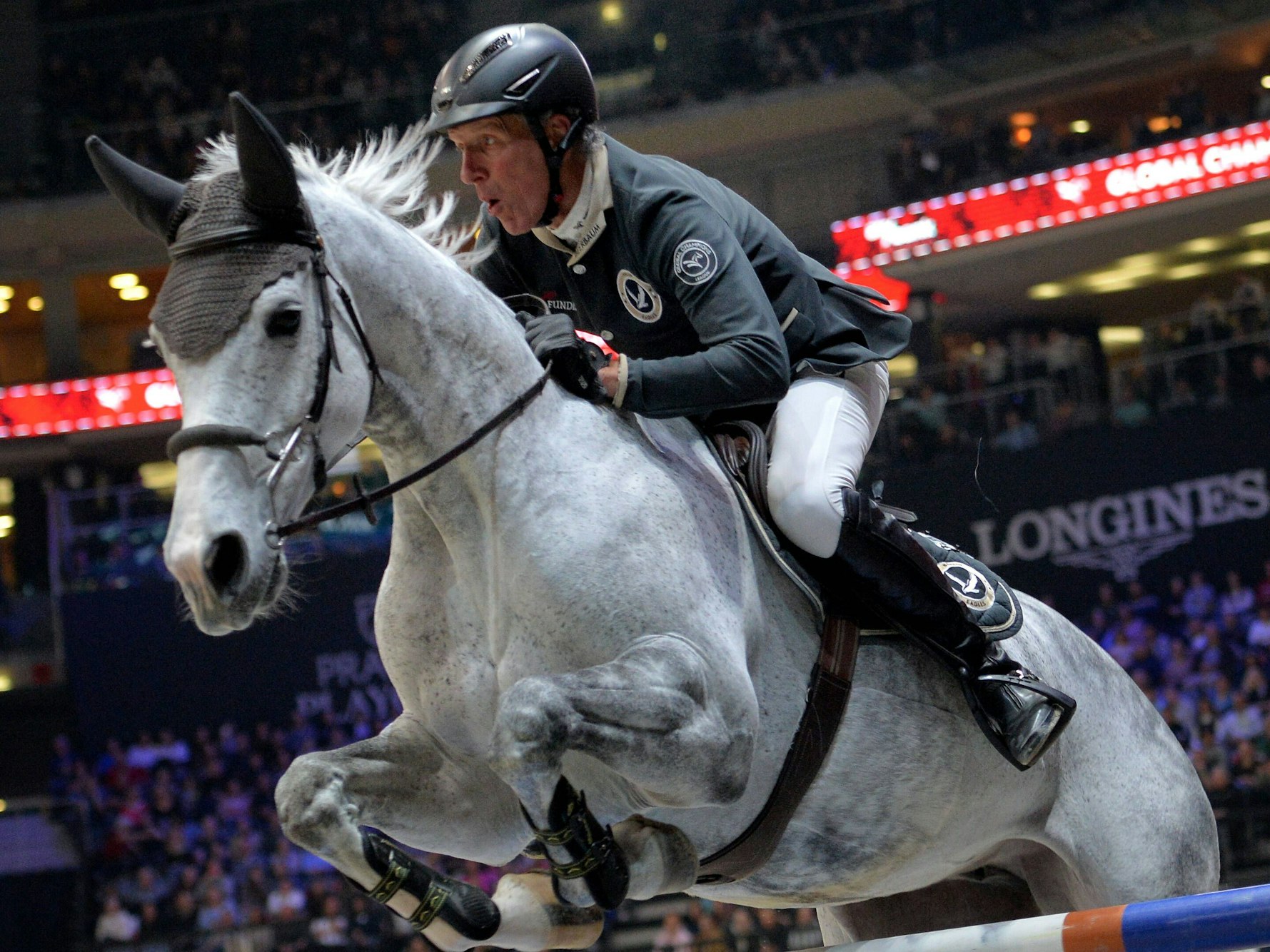 Ludger Beerbaum springt auf einem Pferd über ein Hindernis.