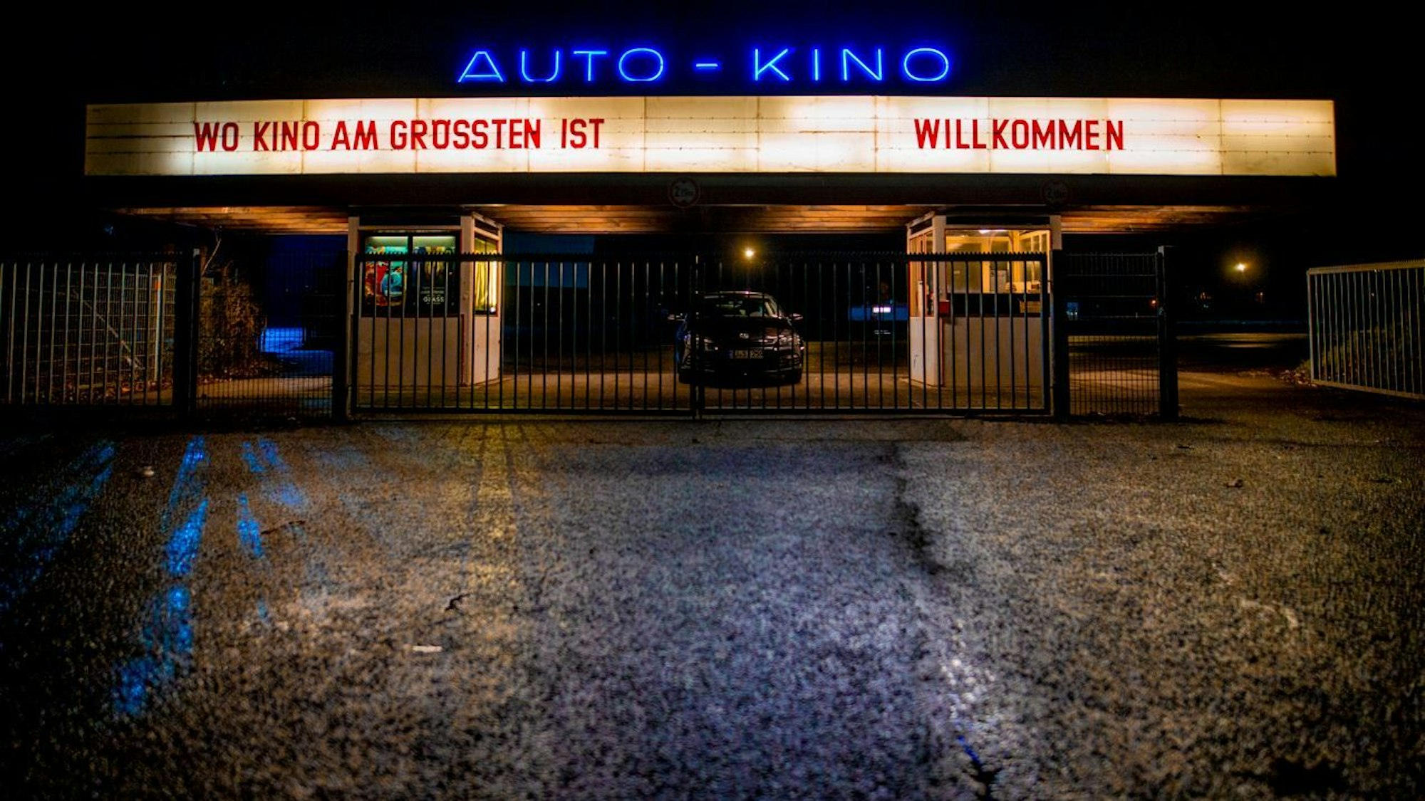 Die Einfahrt zum Autokino in Porz. Sie ist wegen der Dunkelheit hell erleuchtet.
