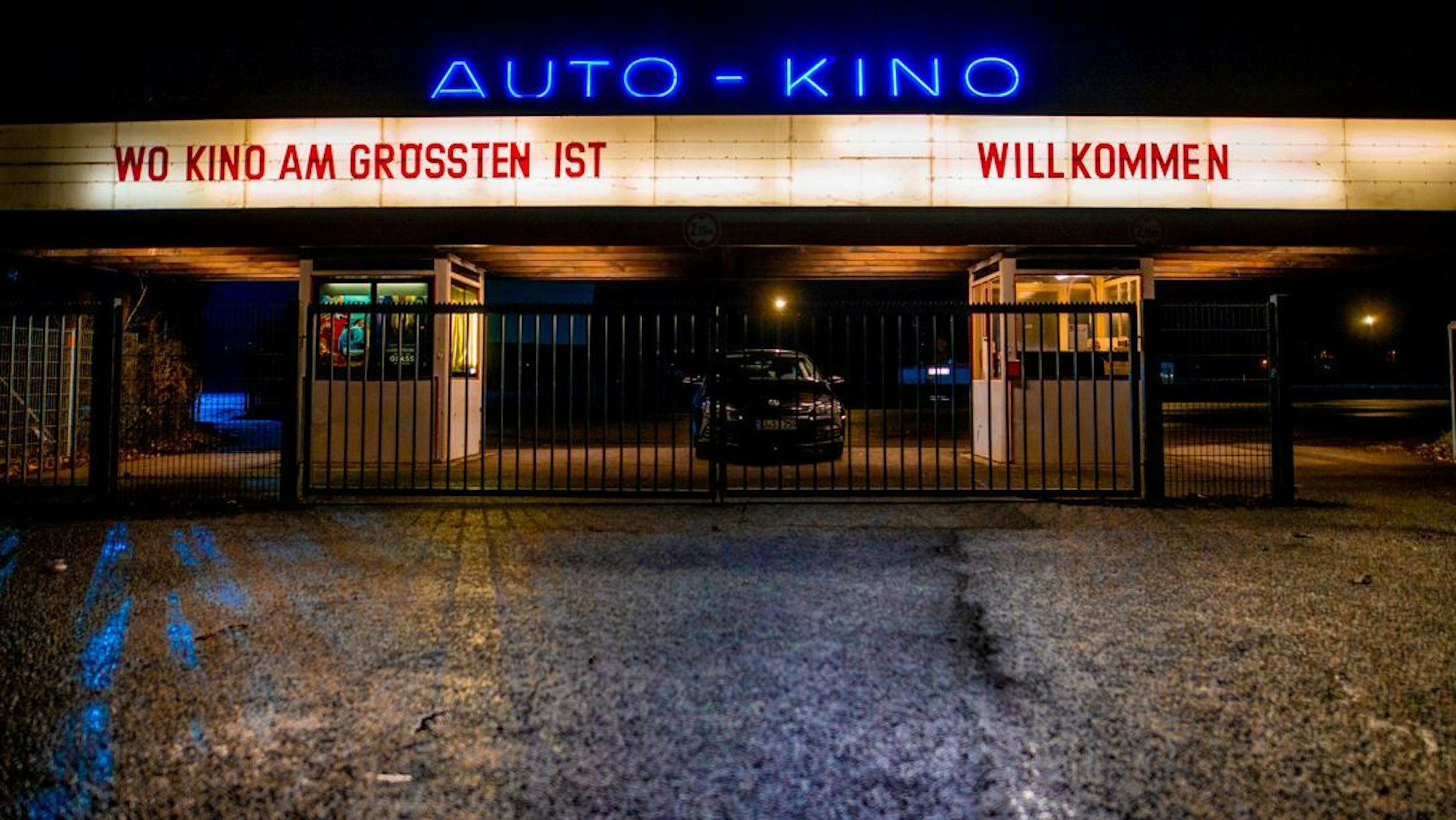 Die Einfahrt zum Autokino in Porz. Sie ist wegen der Dunkelheit hell erleuchtet.